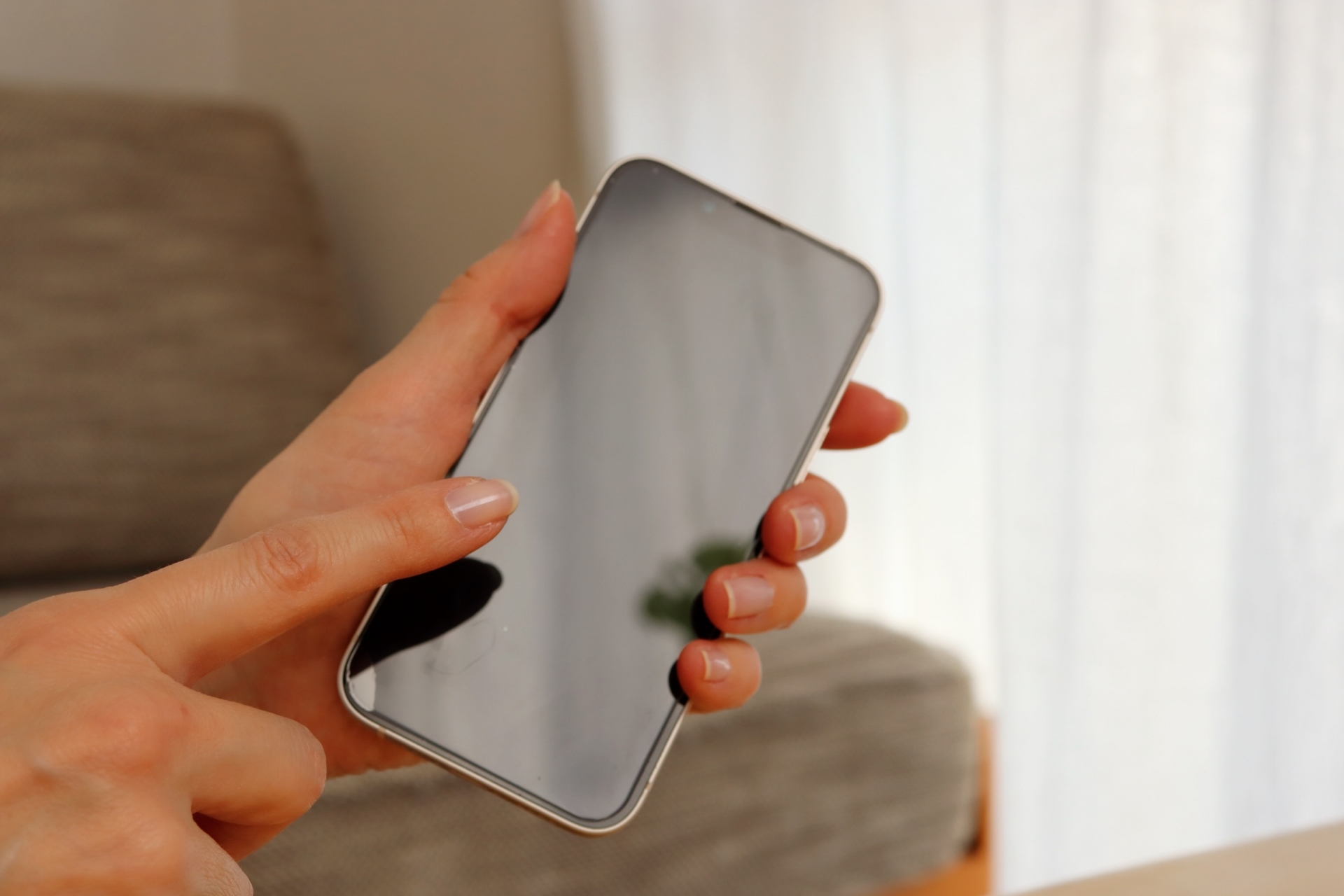 スマホを指さす女性の手元
