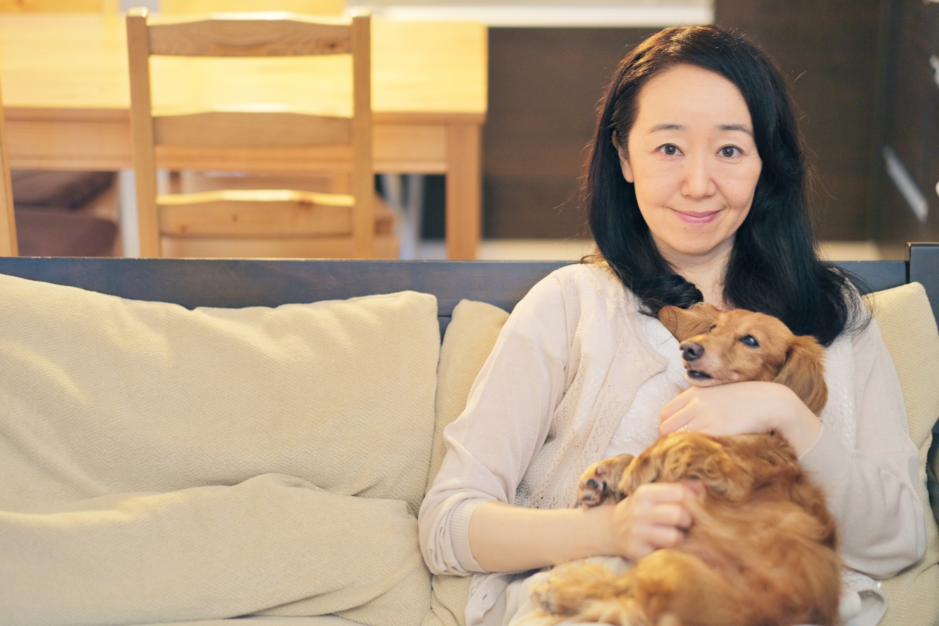 ソファで犬とくつろぐ女性