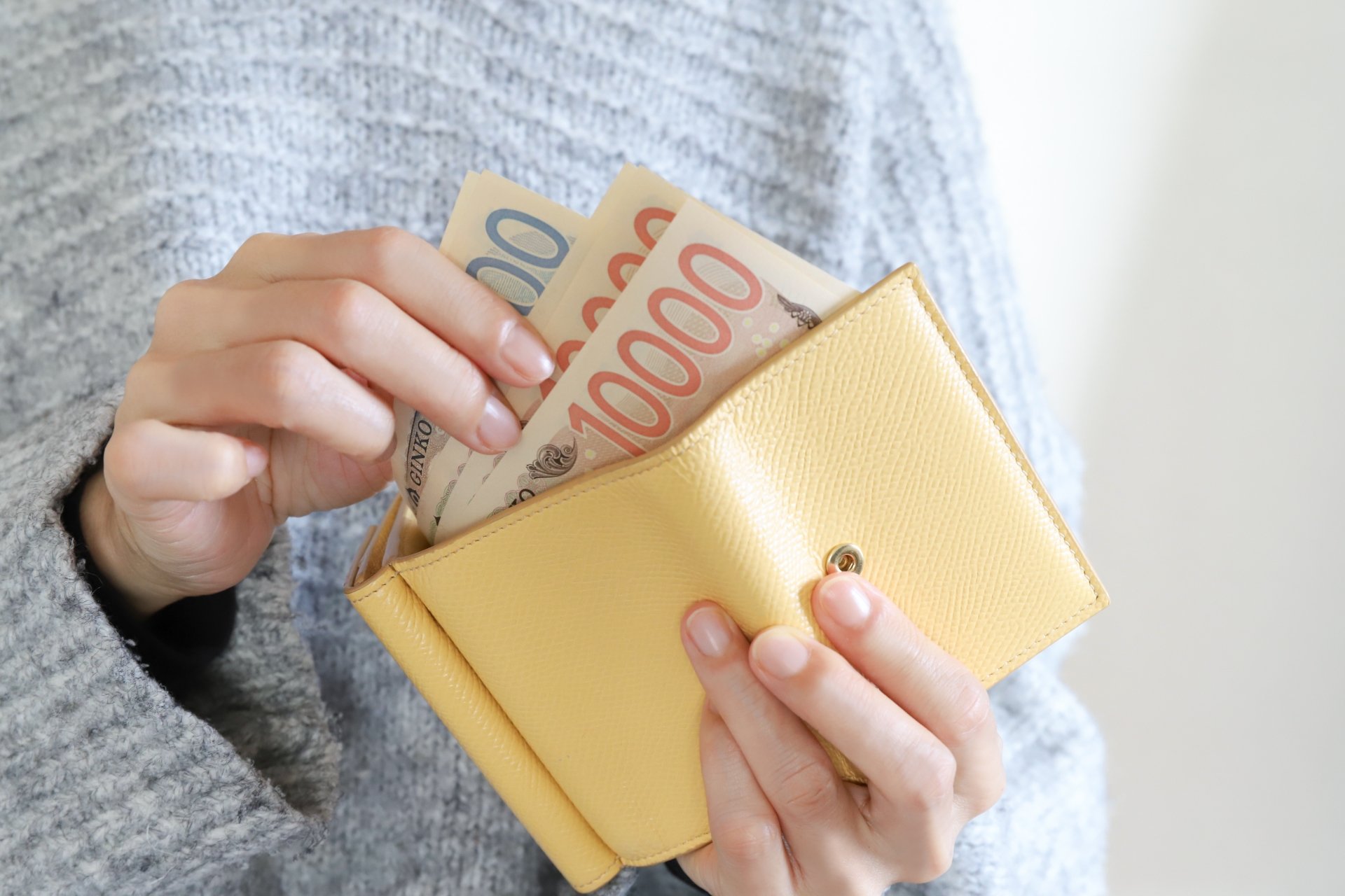 財布からお金を出す主婦