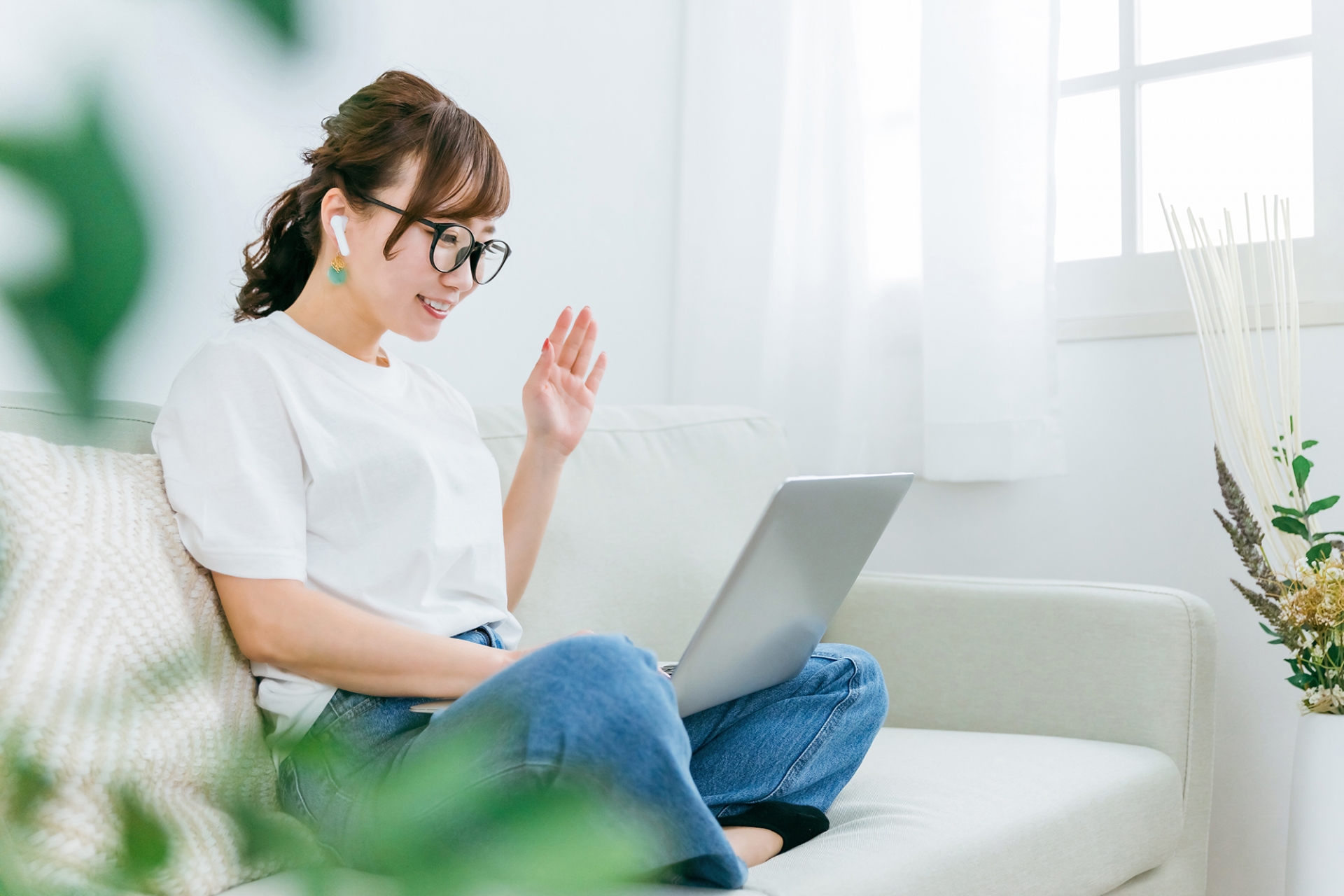 パソコンでテレワークして挨拶する女性
