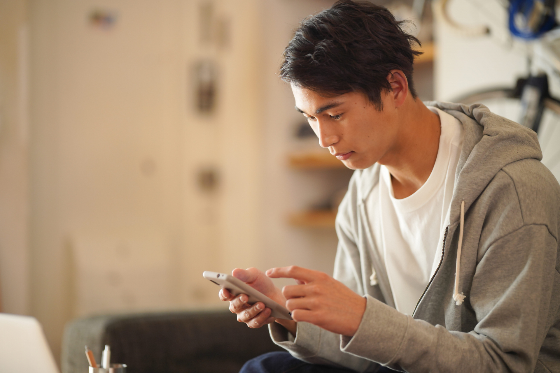 ソファーでスマホを使う男性