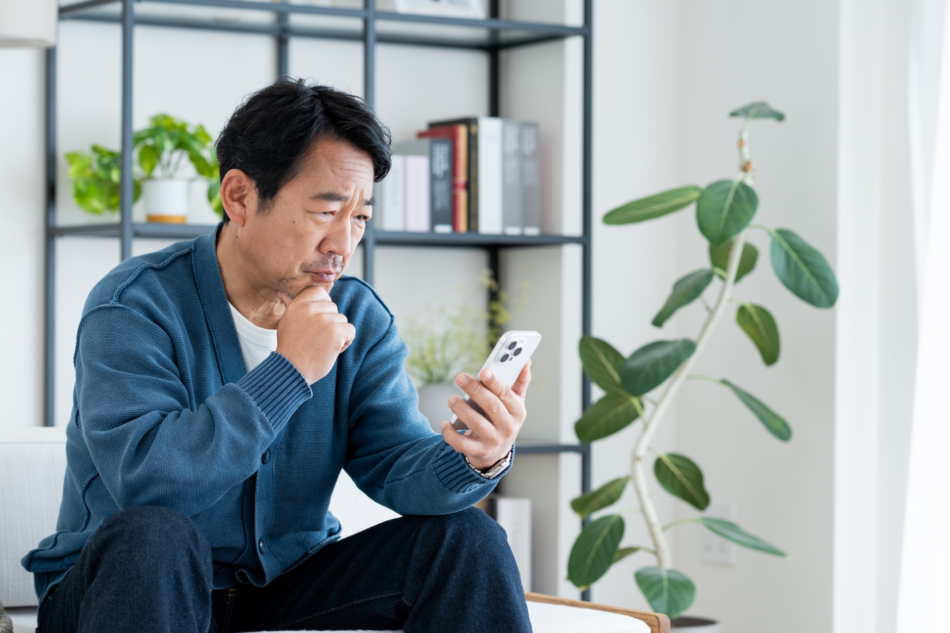 スマホを見て悩む男性