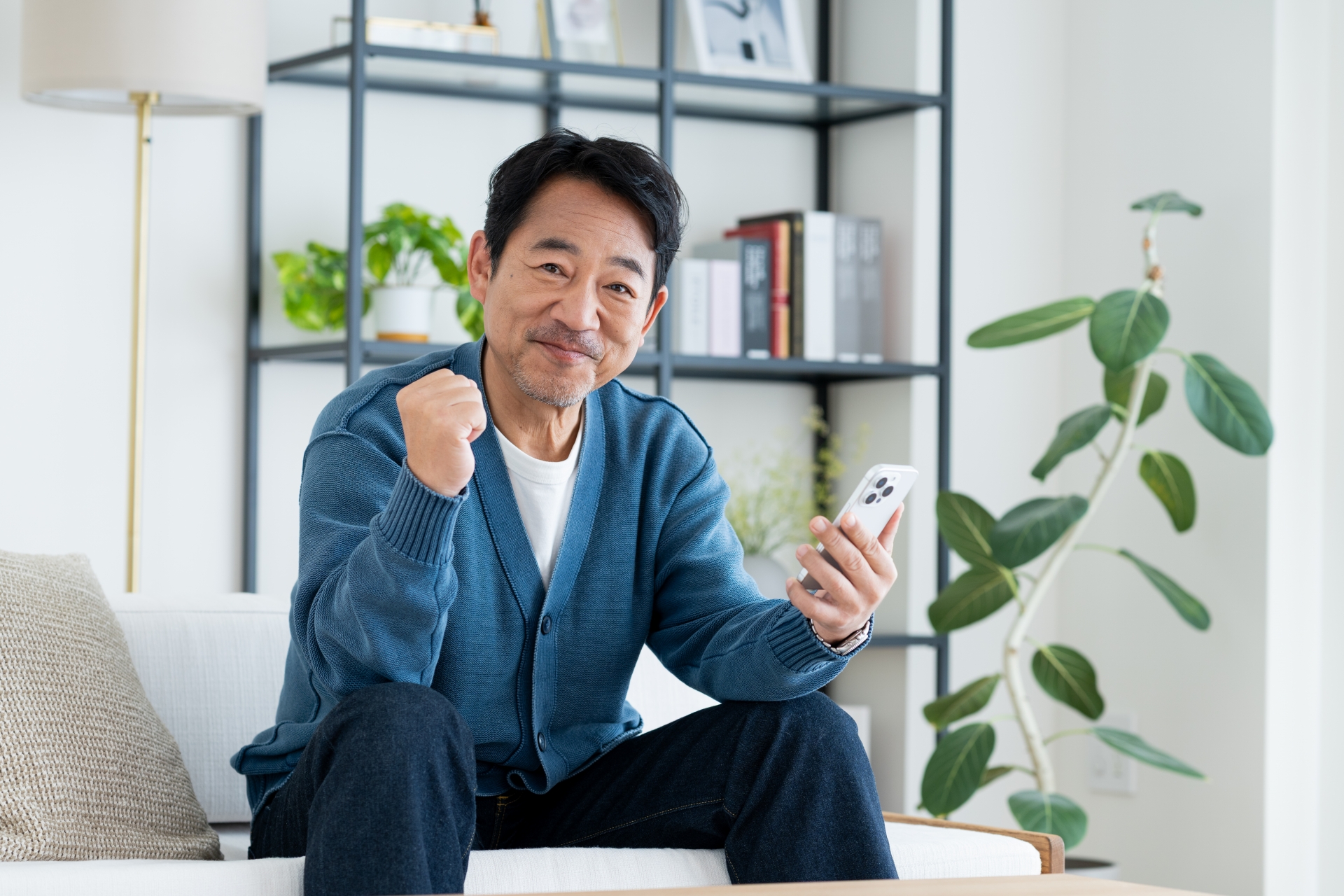 スマホでガッツポーズするミドルの男性