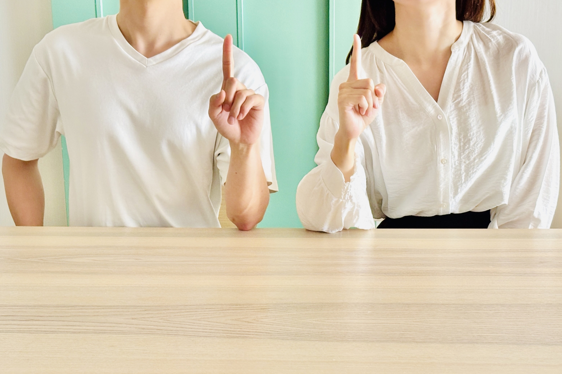 人差し指を立てている2人の女性