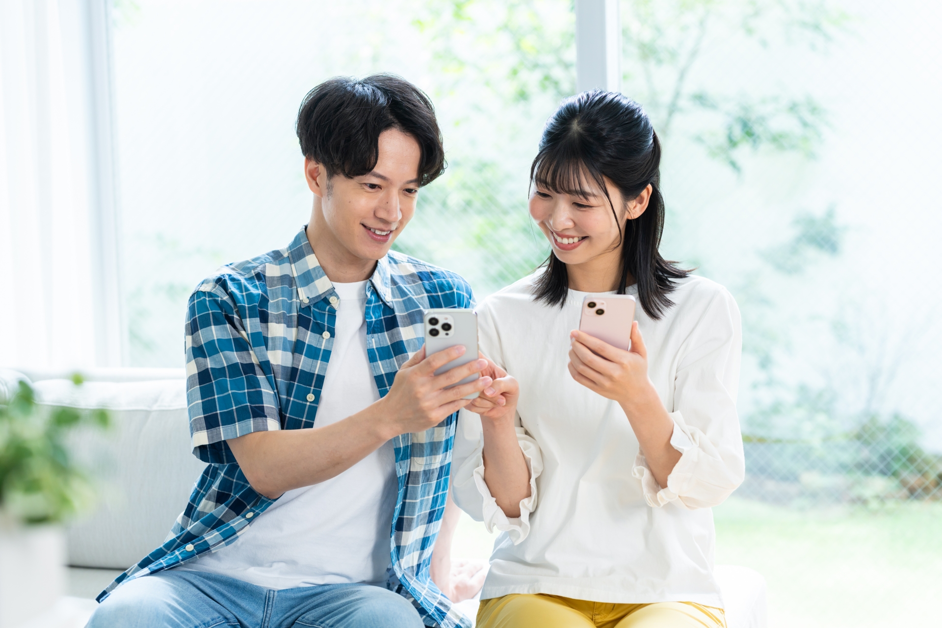 リビングでスマホを見るカップル