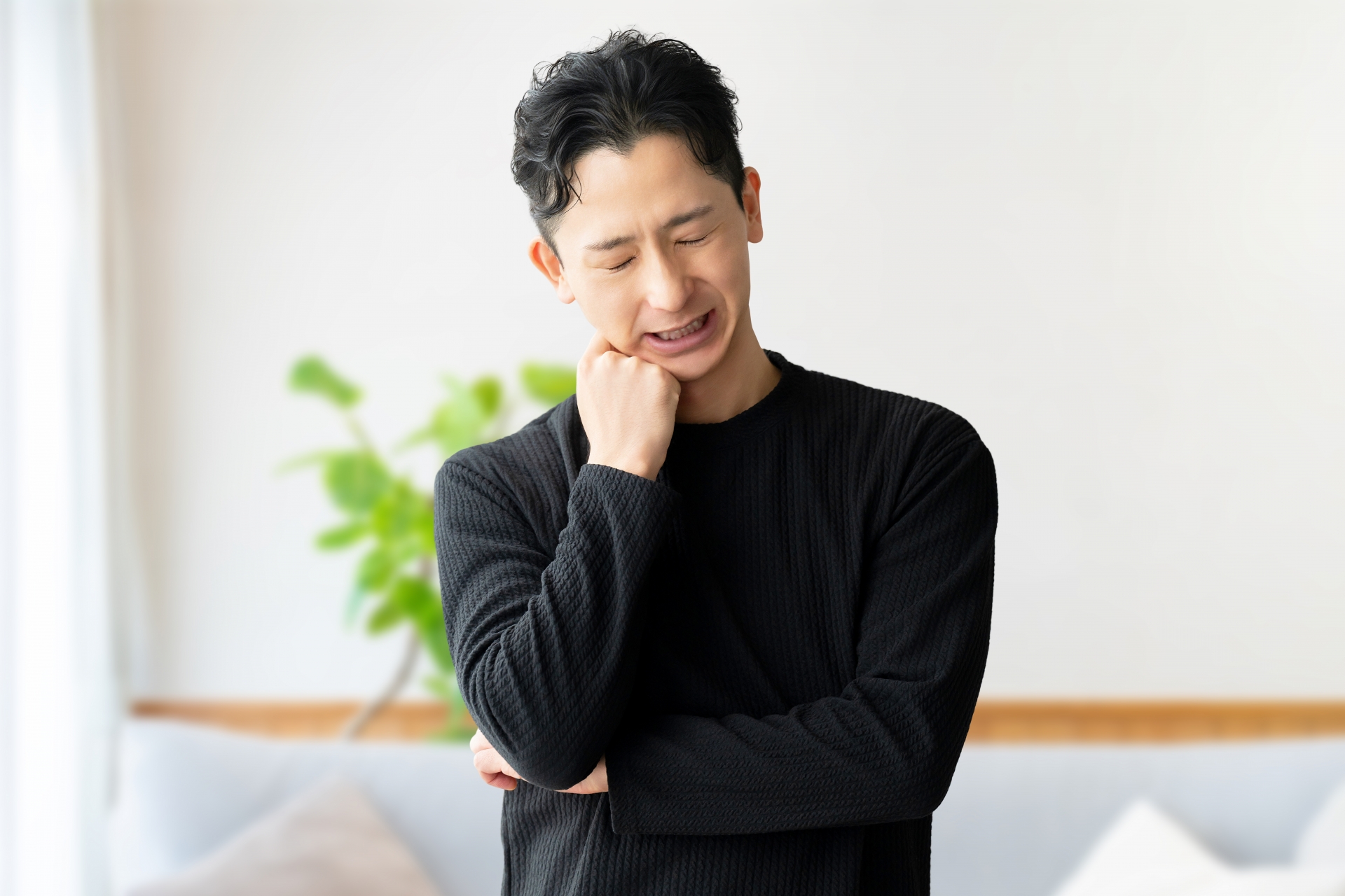 手をあごにつけて考え込む男性