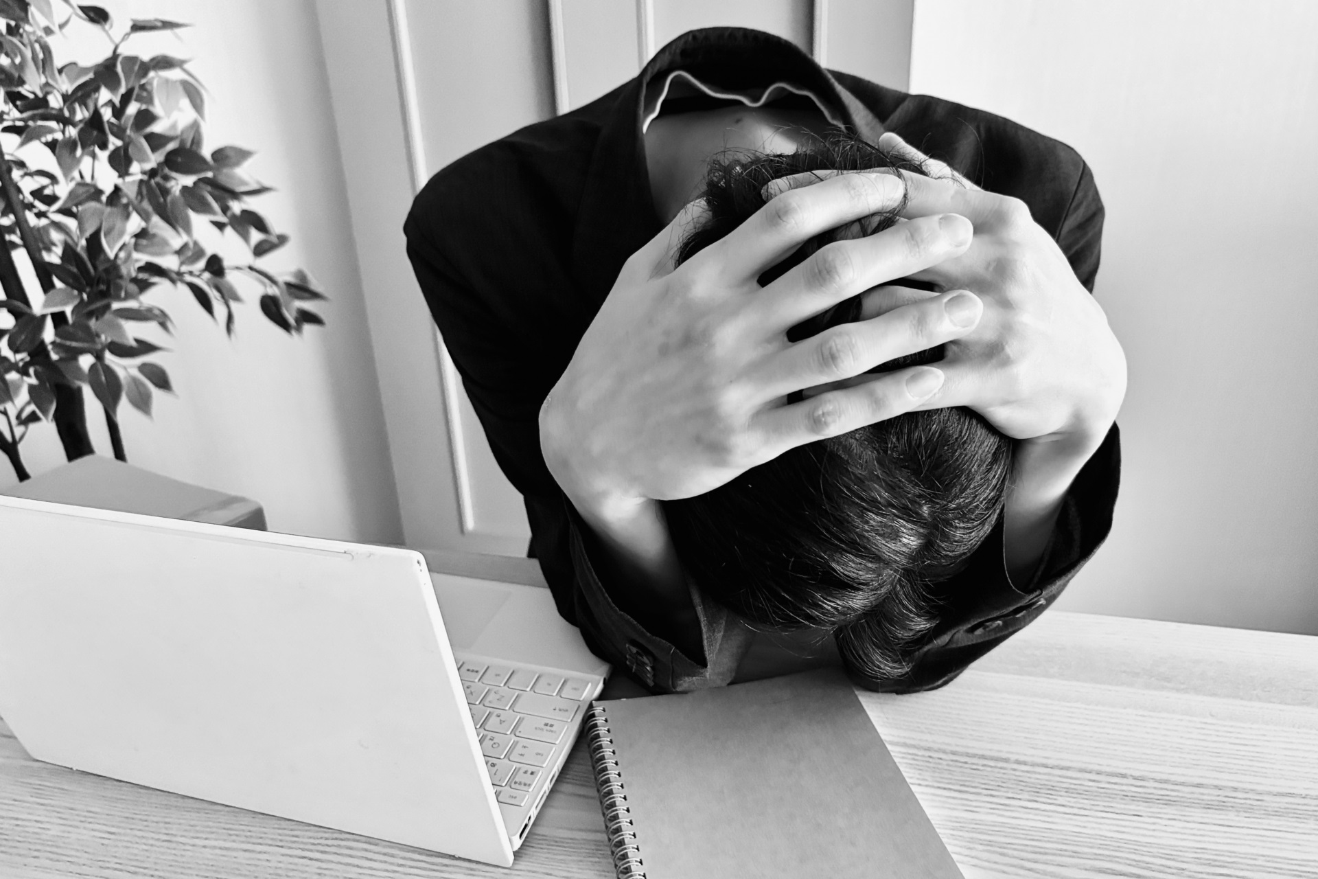 デスクで頭を抱える男性