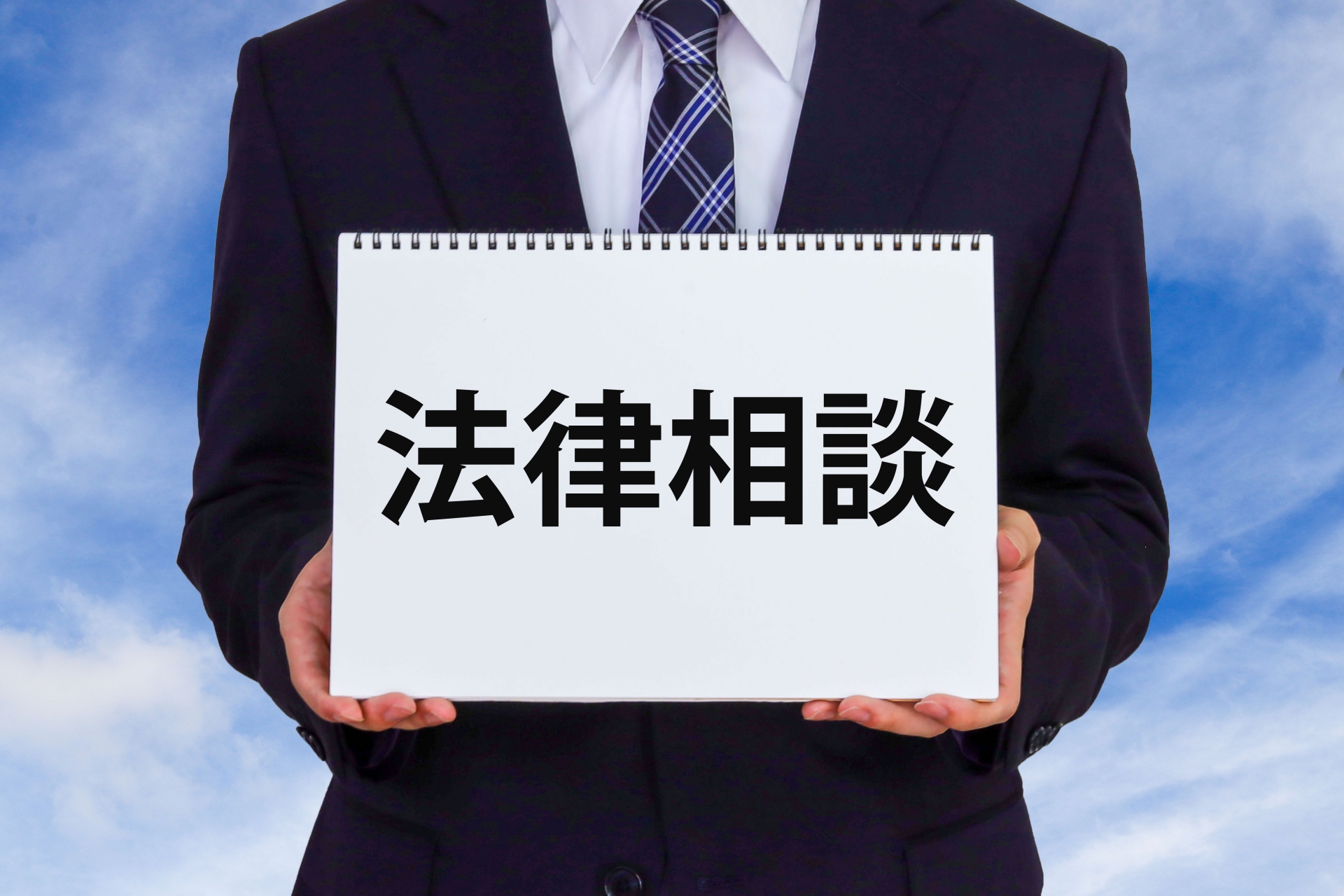 法律相談と書かれたノートを持つ男性
