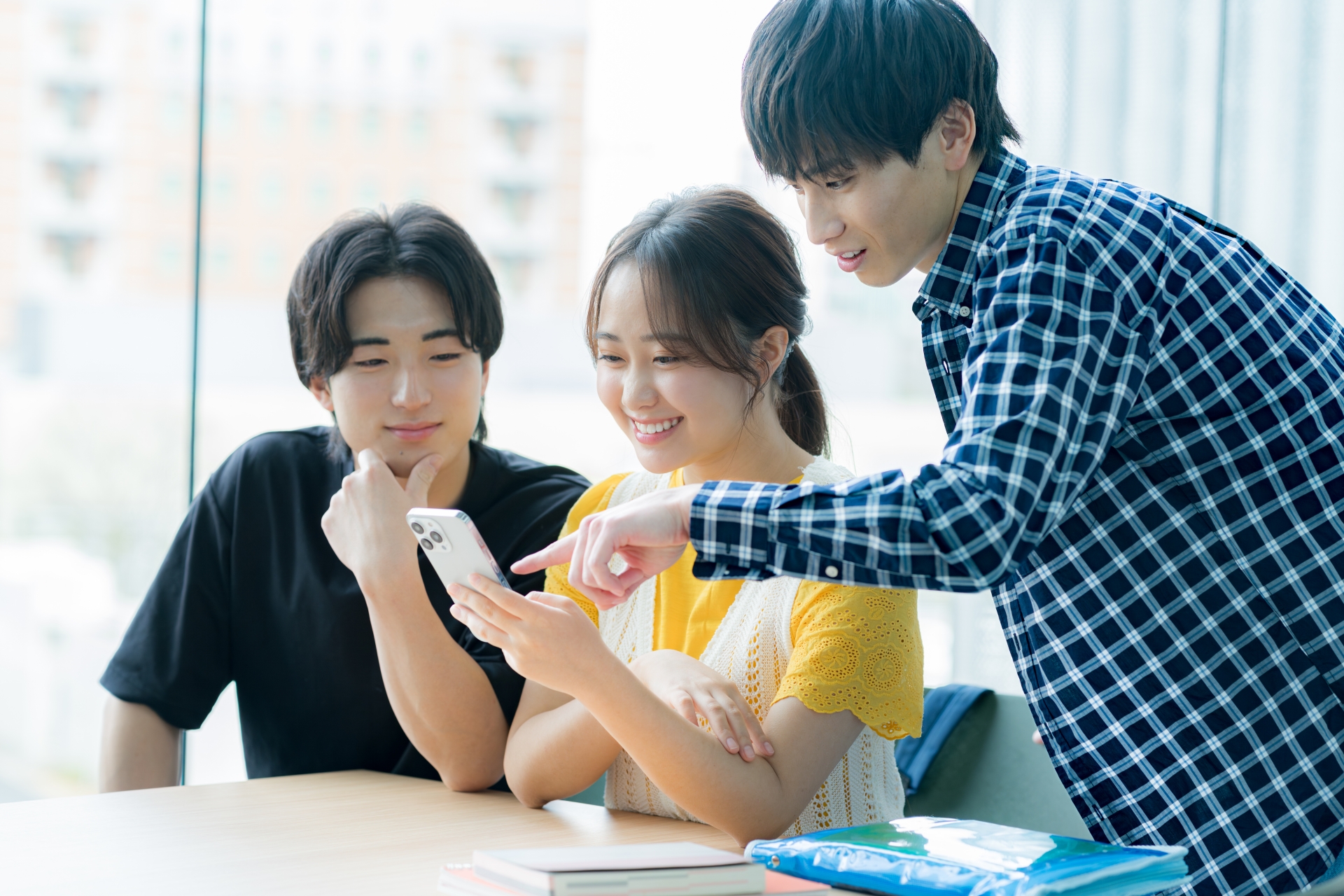 スマホを見ながら話す学生たち