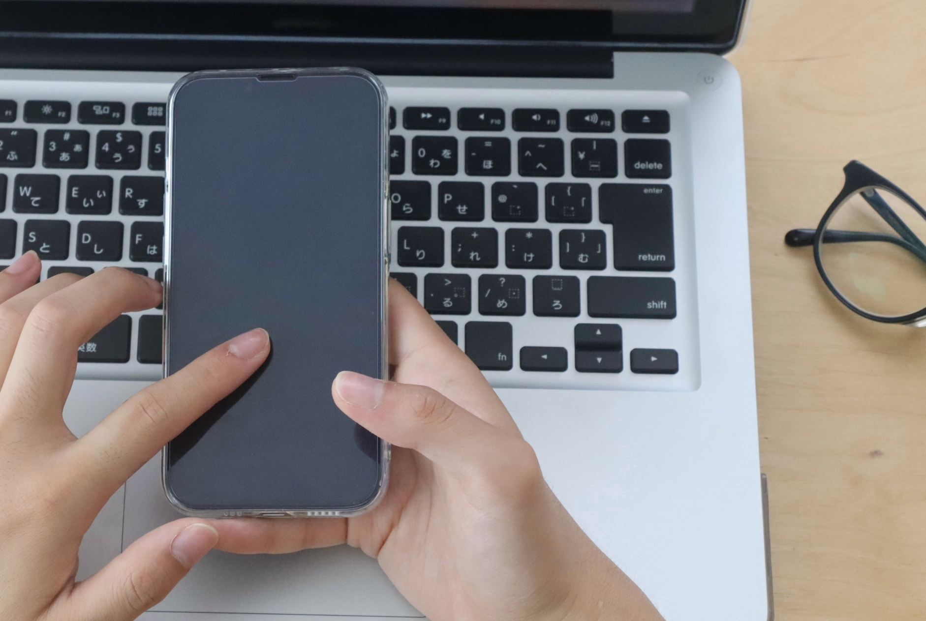 スマホを指さす男性の手