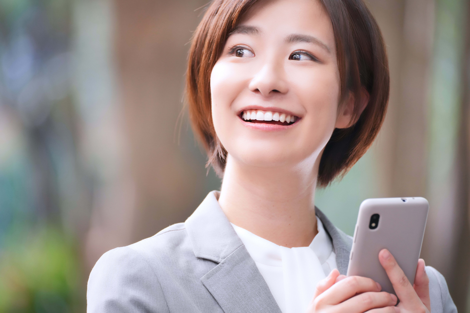スマホを持ち振り向く女性