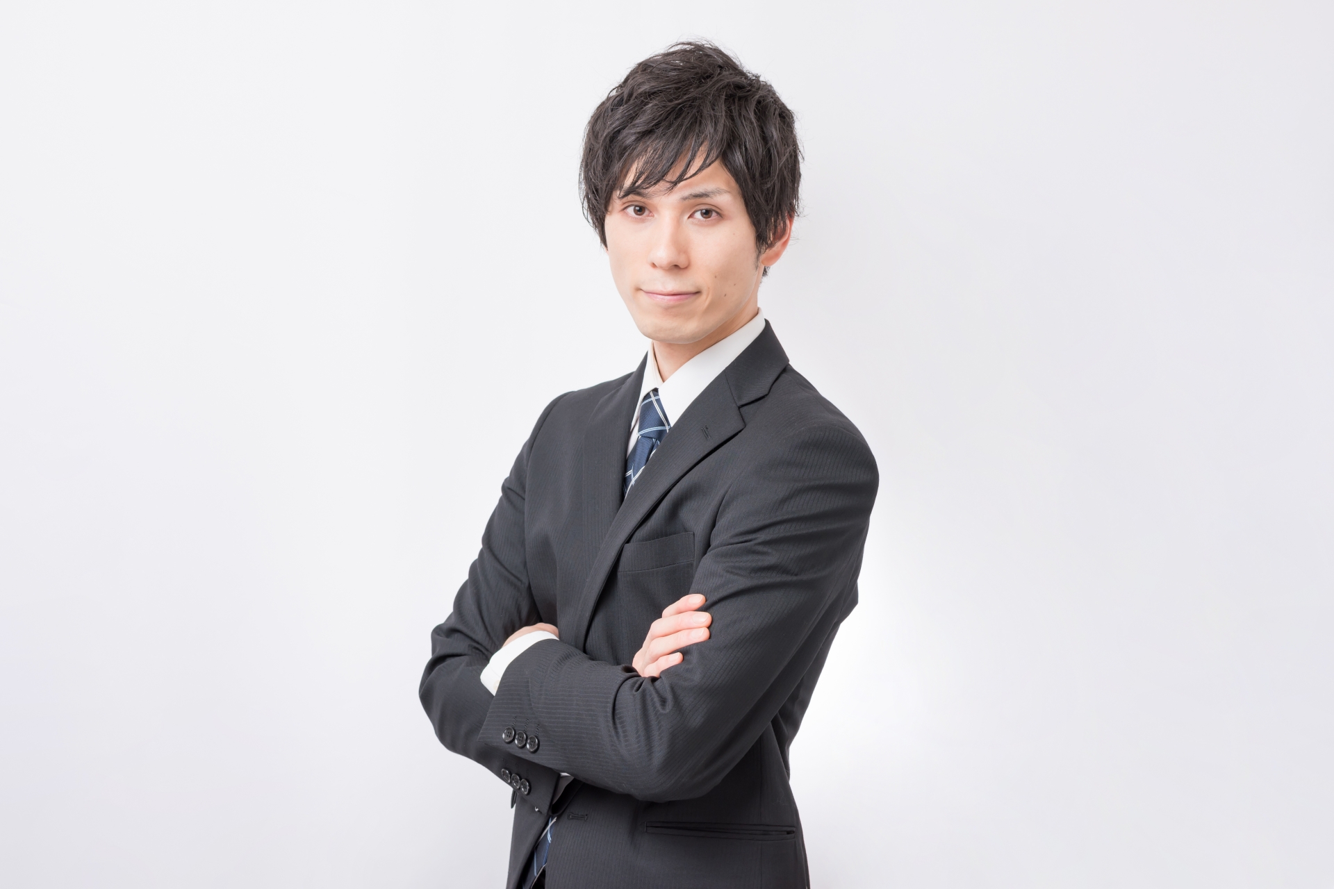 腕組みをするスーツの男性