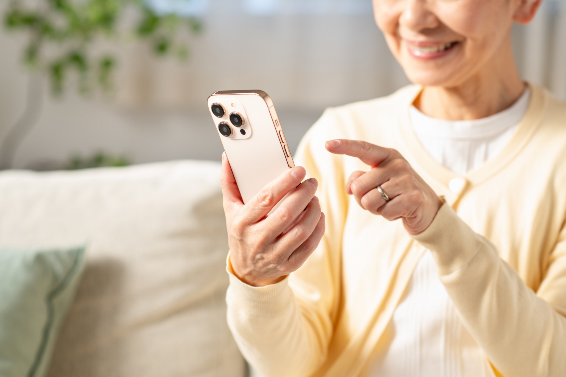 リビングでスマホを使うシニア女性