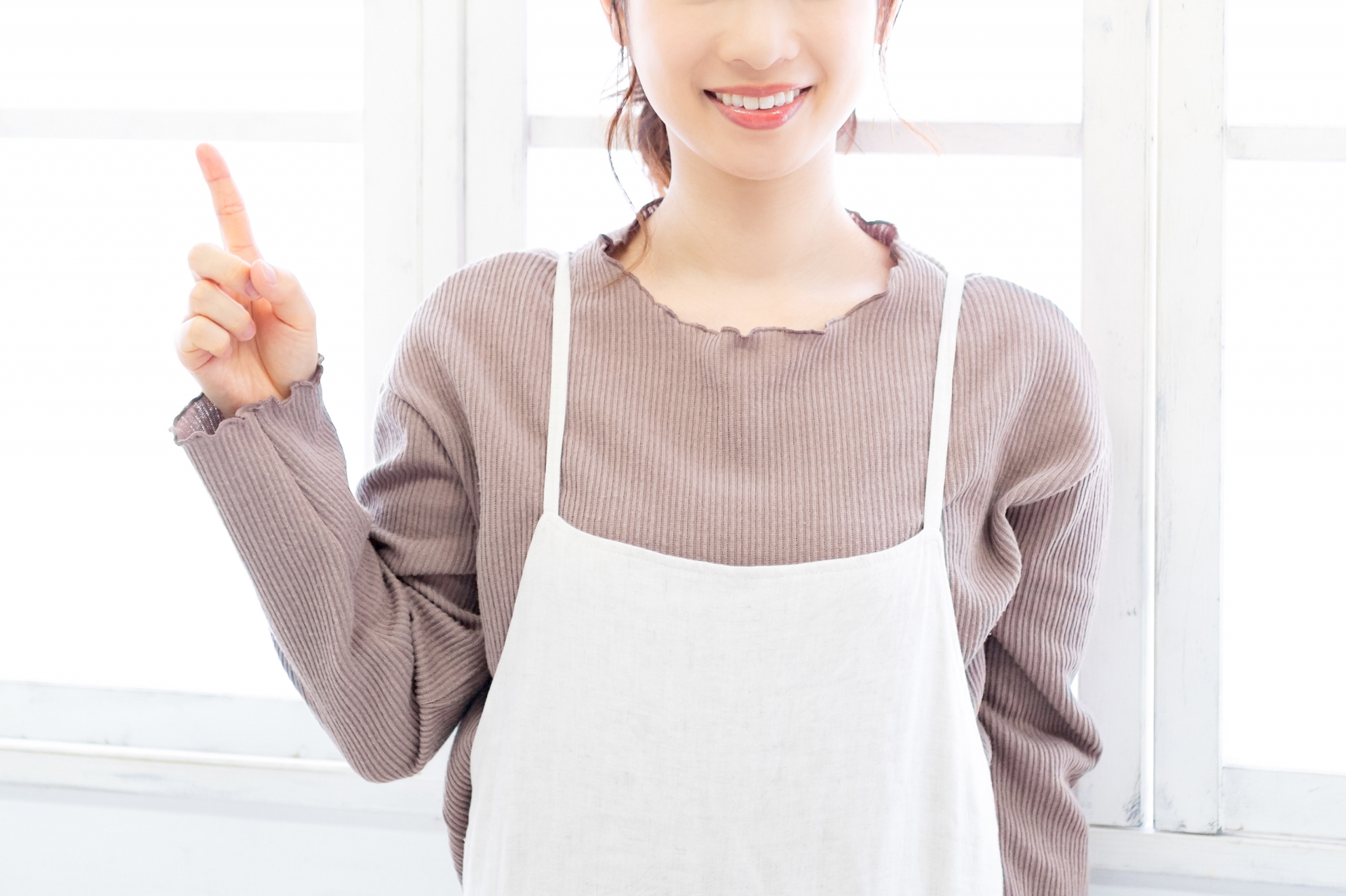 指を立てて案内する女性