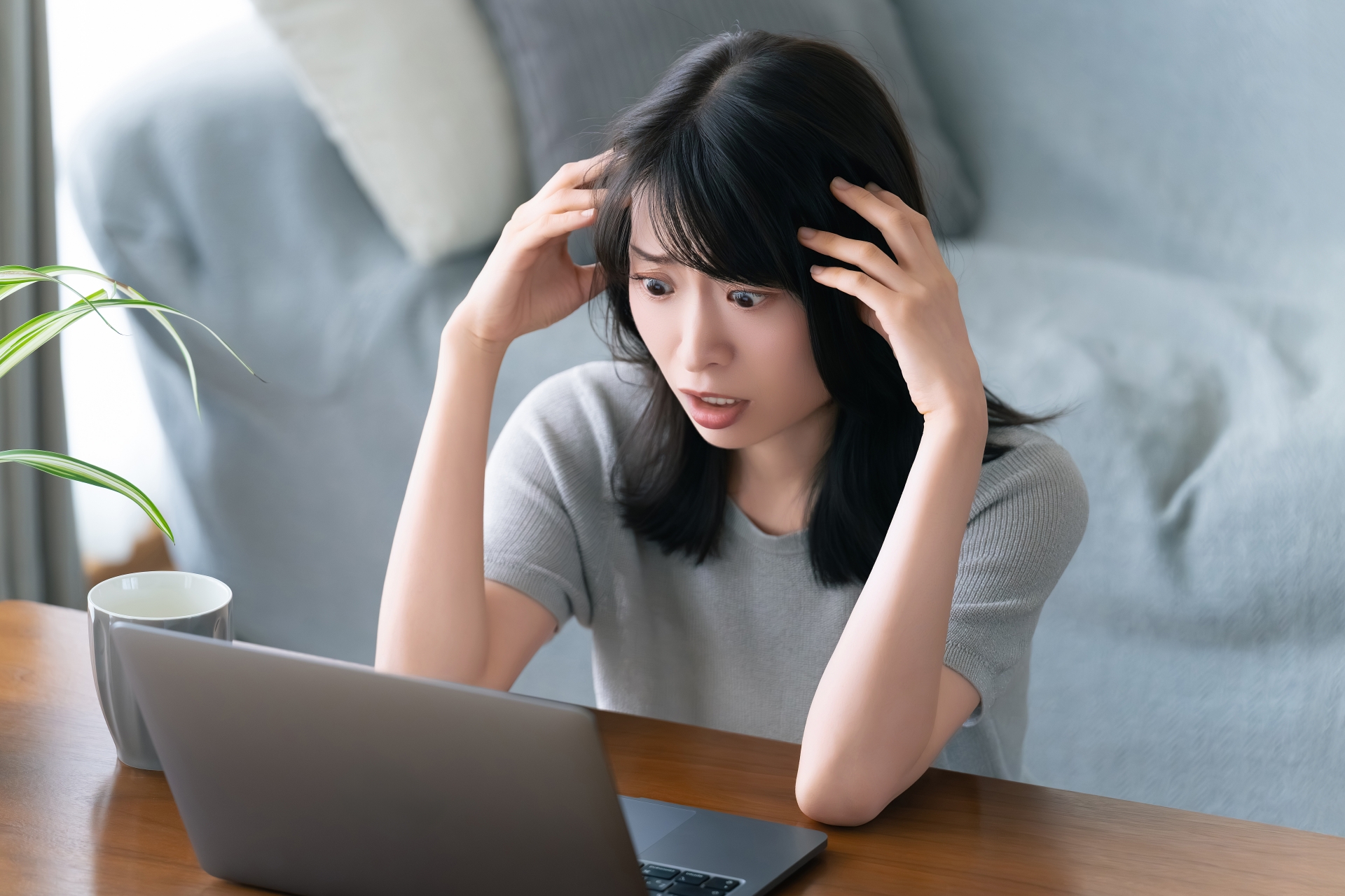 パソコンの前で頭を抱える女性