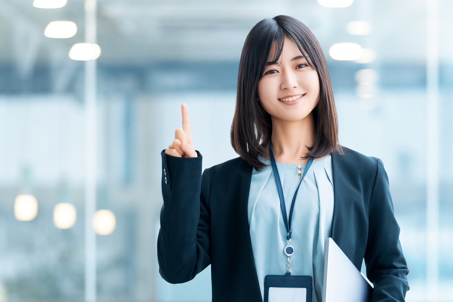 指を立てて案内する若い女性