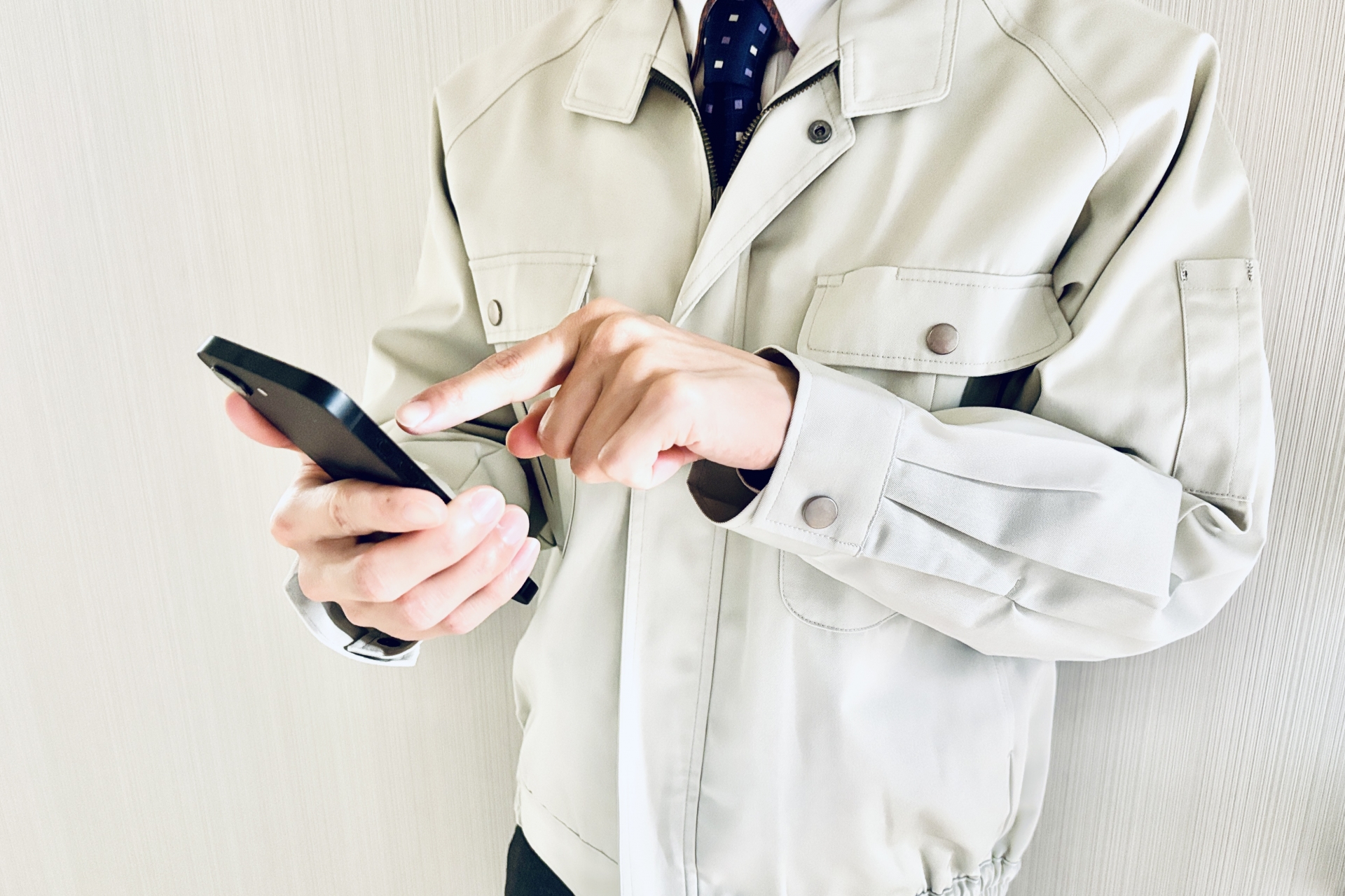 スマホを使用する作業着の男性