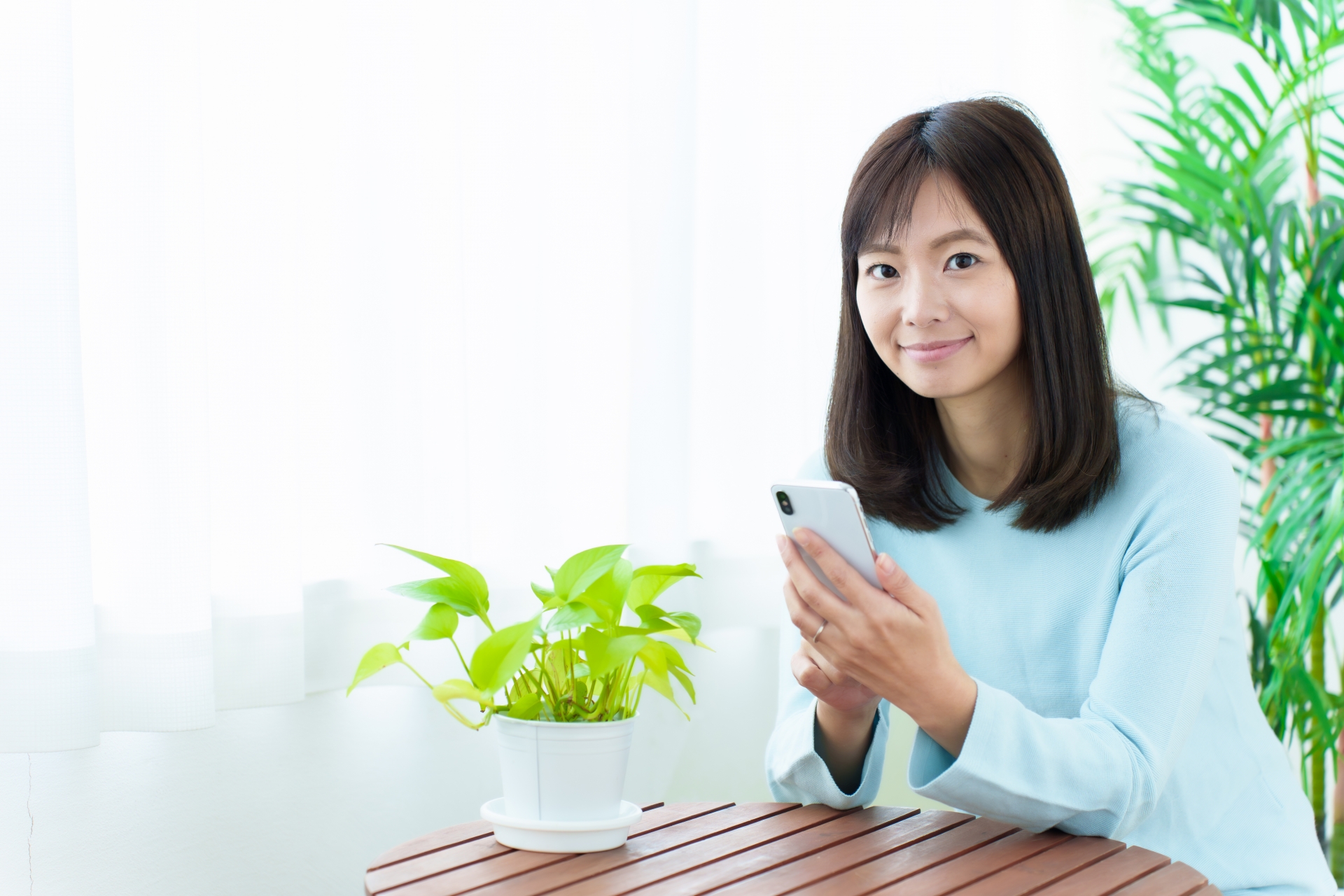 スマホを手に取る女性