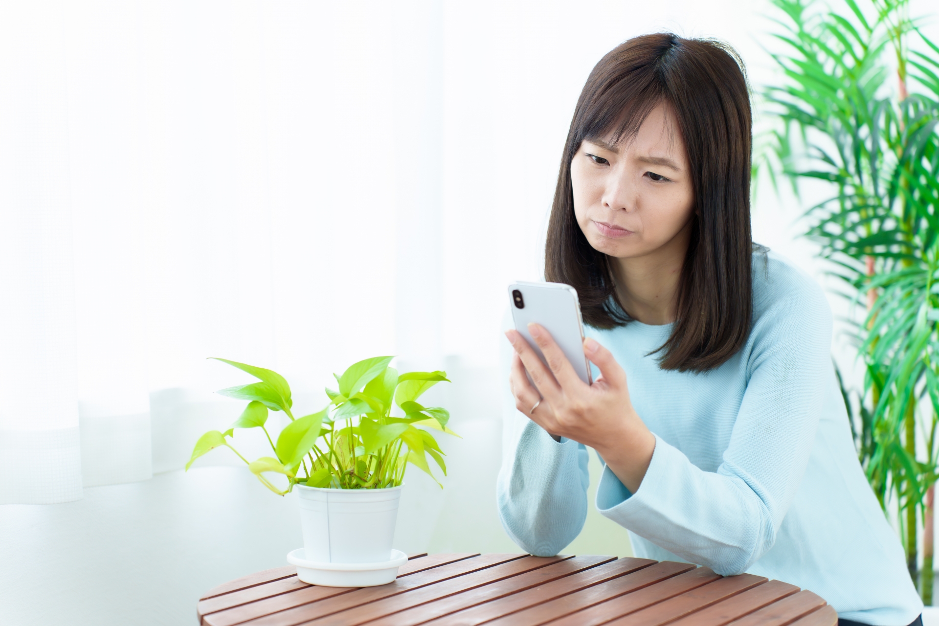 スマホを見て険しい顔をする女性