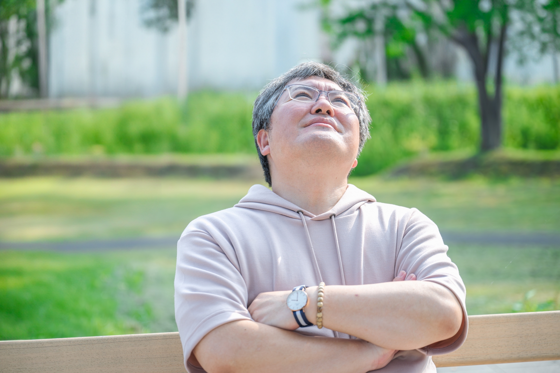 腕組みをして上を見る男性