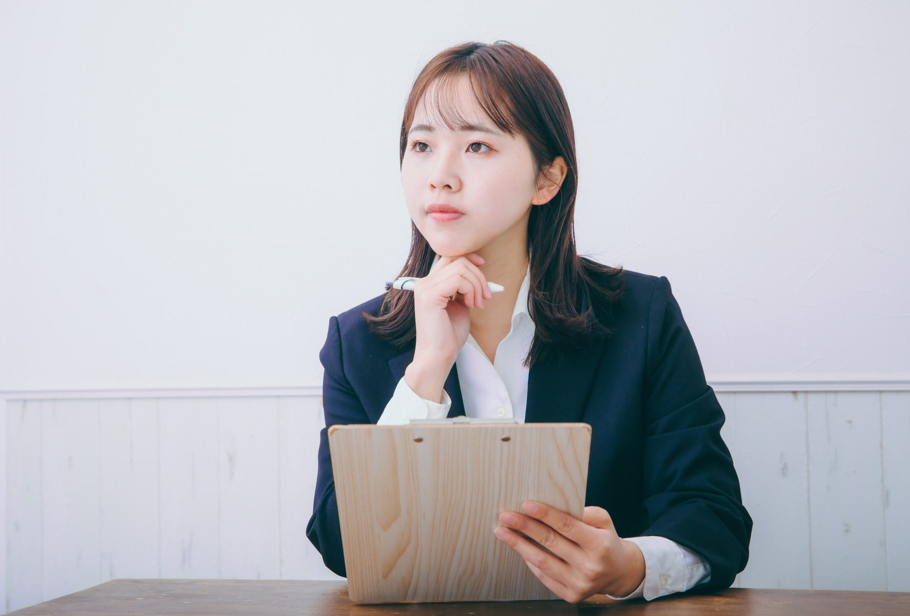 書類を持って悩む女性
