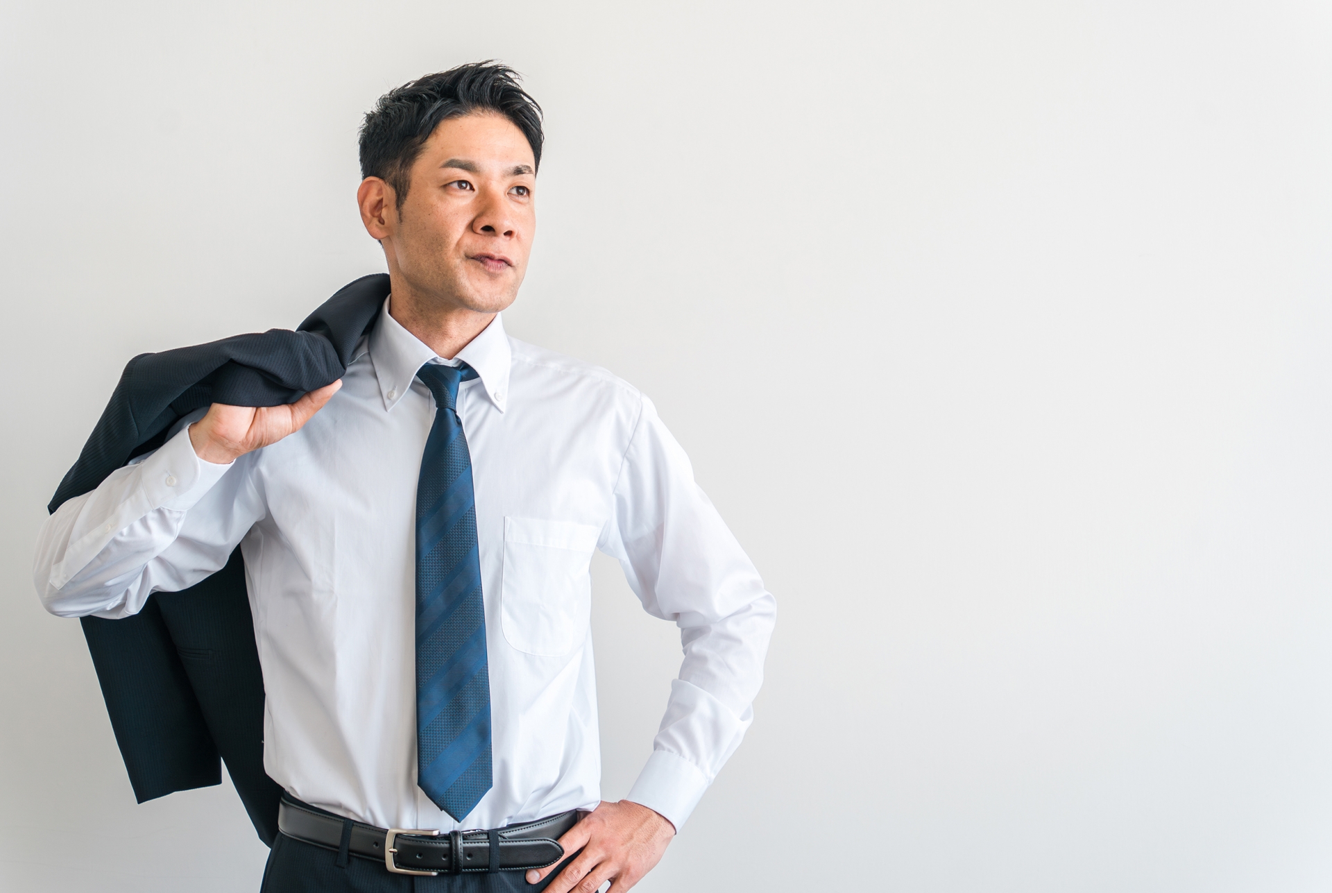 ジャケットを肩に掛ける男性