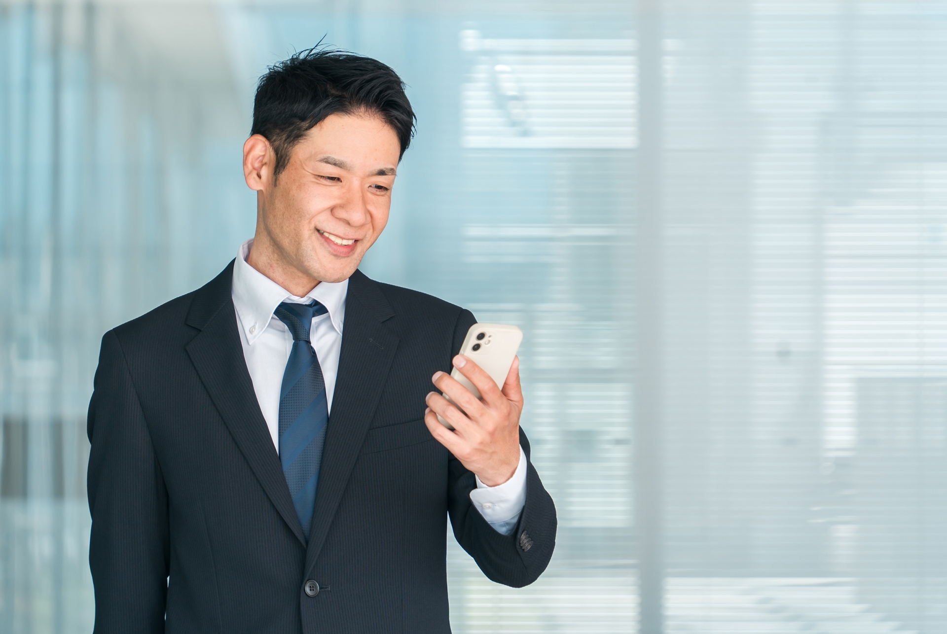 スマホを見るスーツの男性
