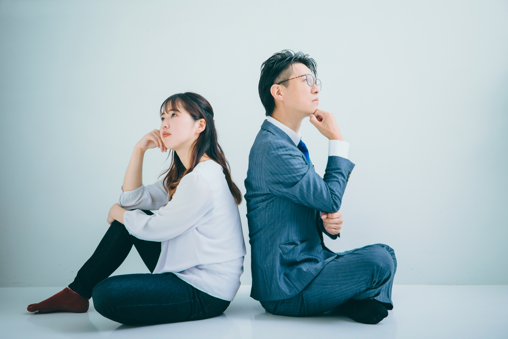 背中合わせに座る男女