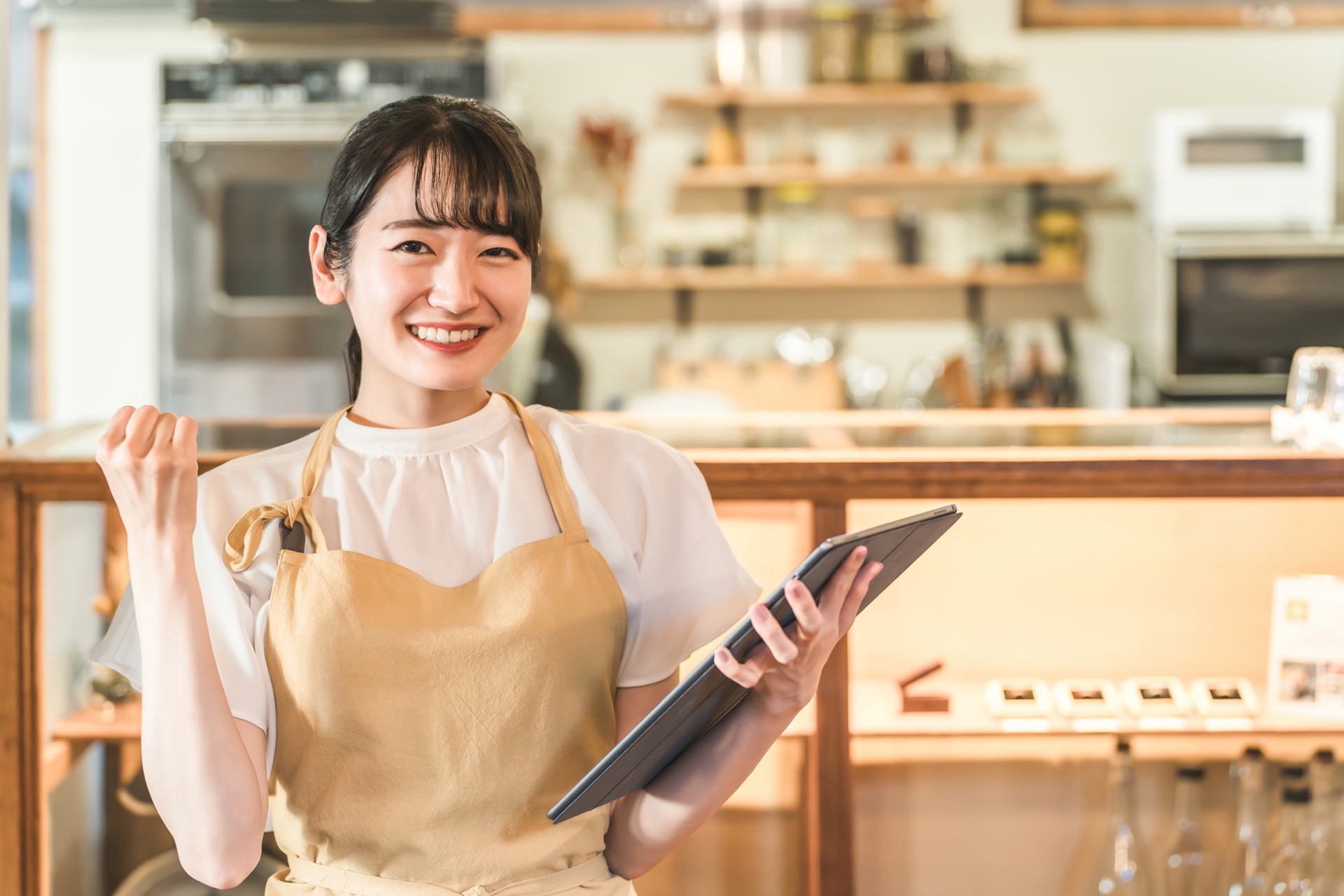 エプロン姿でガッツポーズをする女性