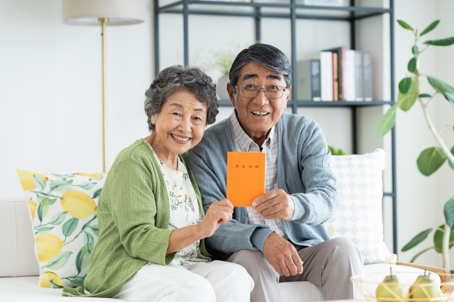 年金手帳を見せる老夫婦