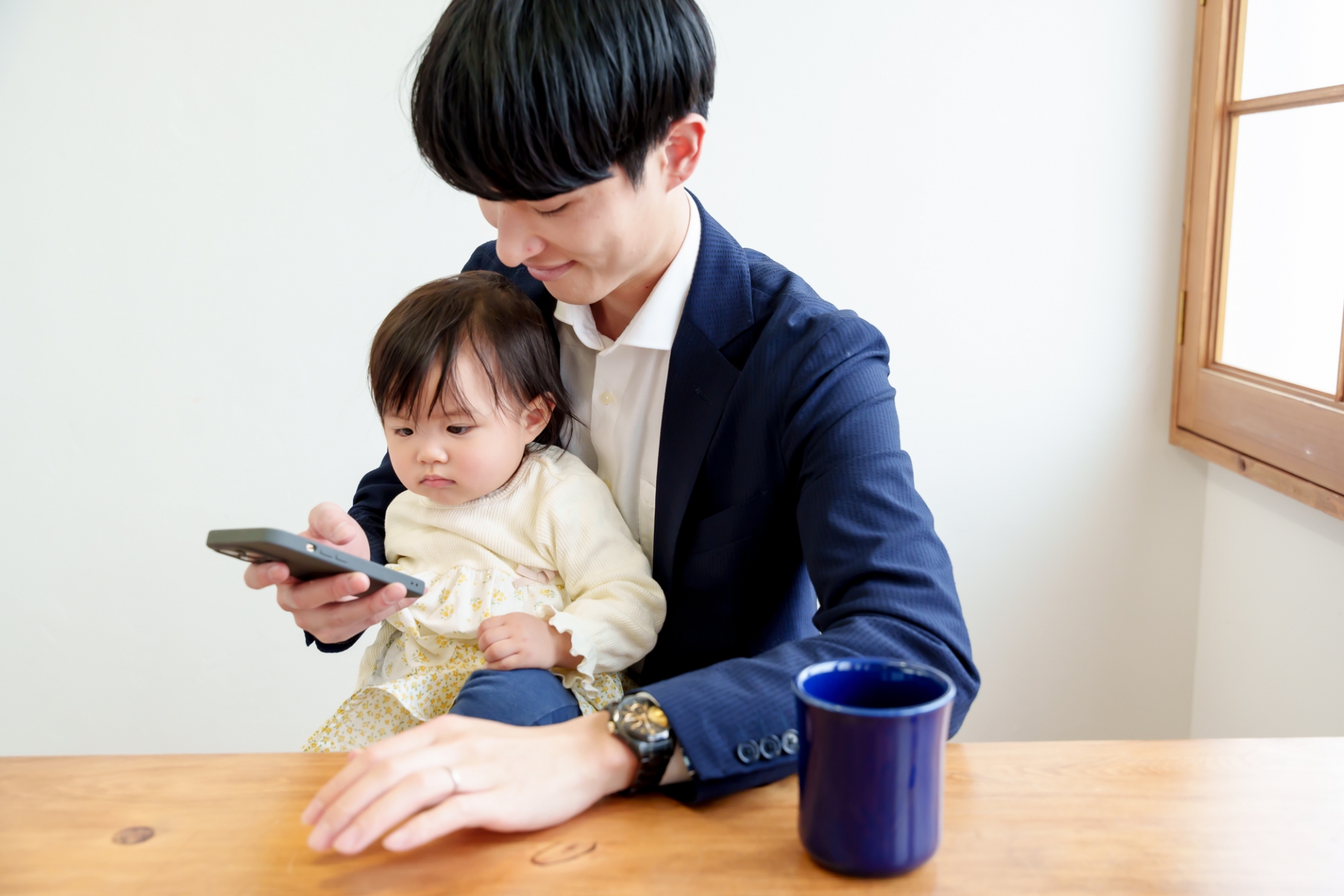 携帯電話を見る父親と子ども