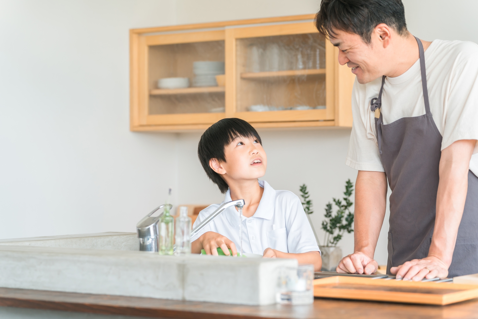 キッチンに立つ父親と子ども