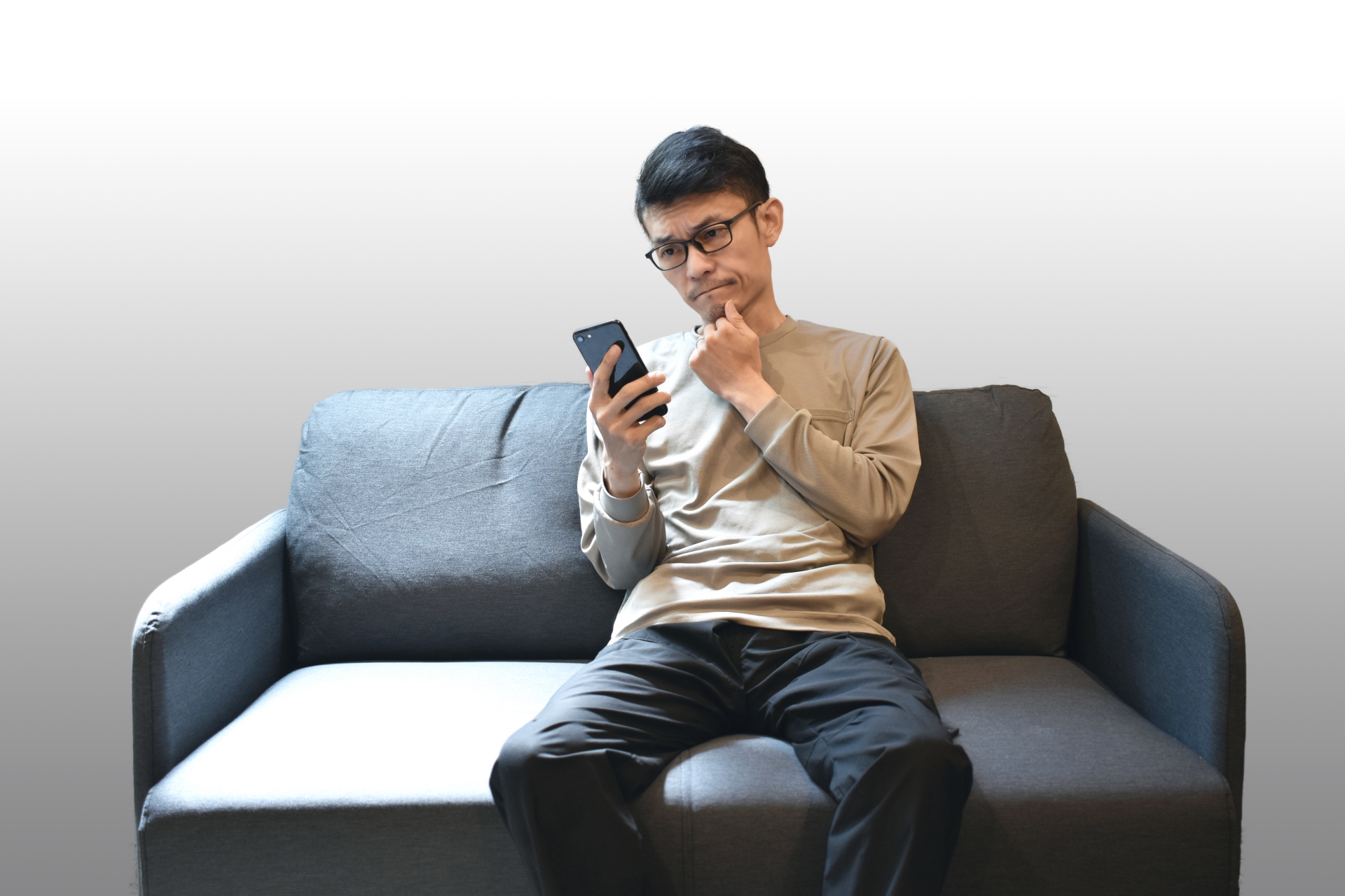 携帯電話を持ち悩む男性