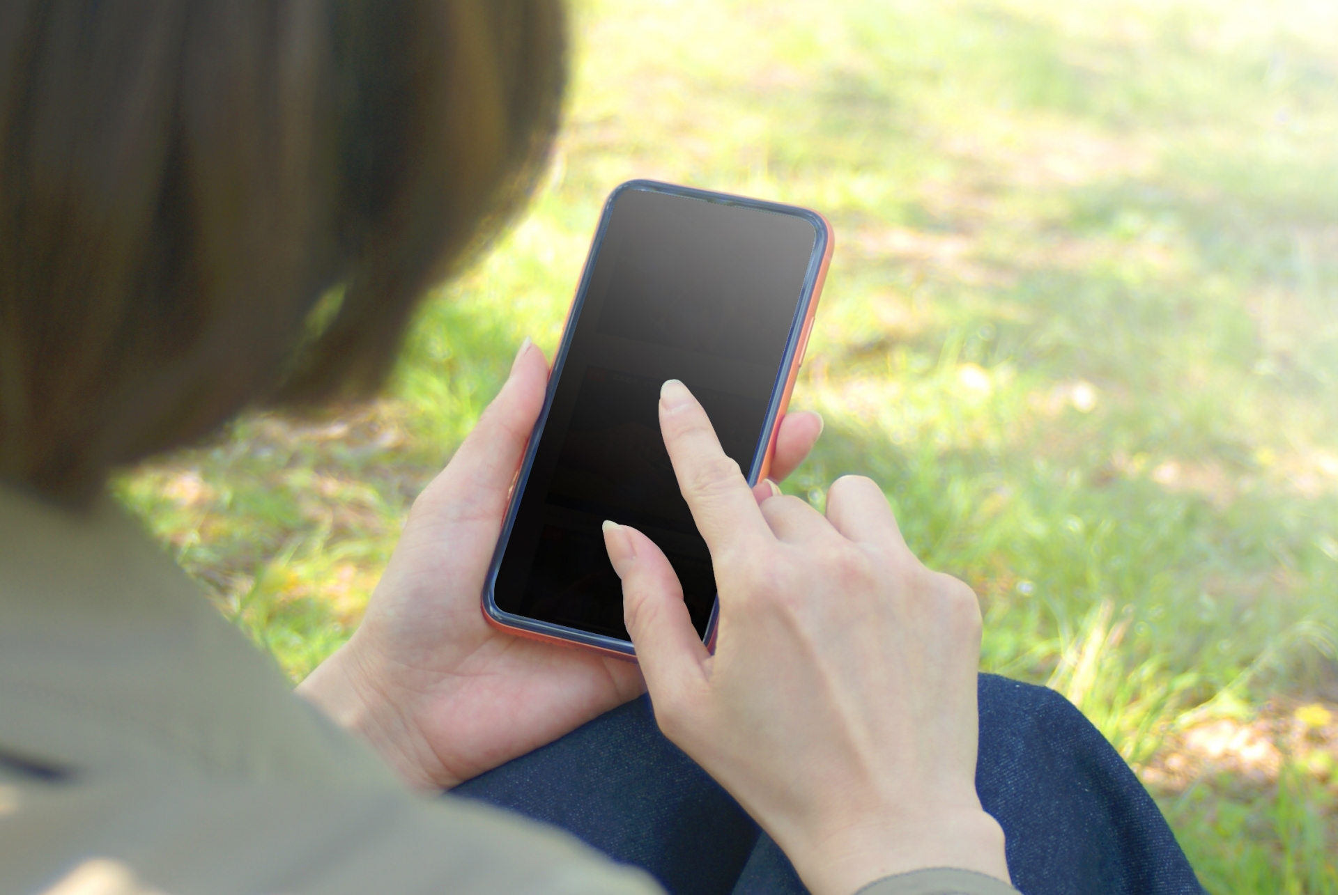 屋外でスマホを触る女性