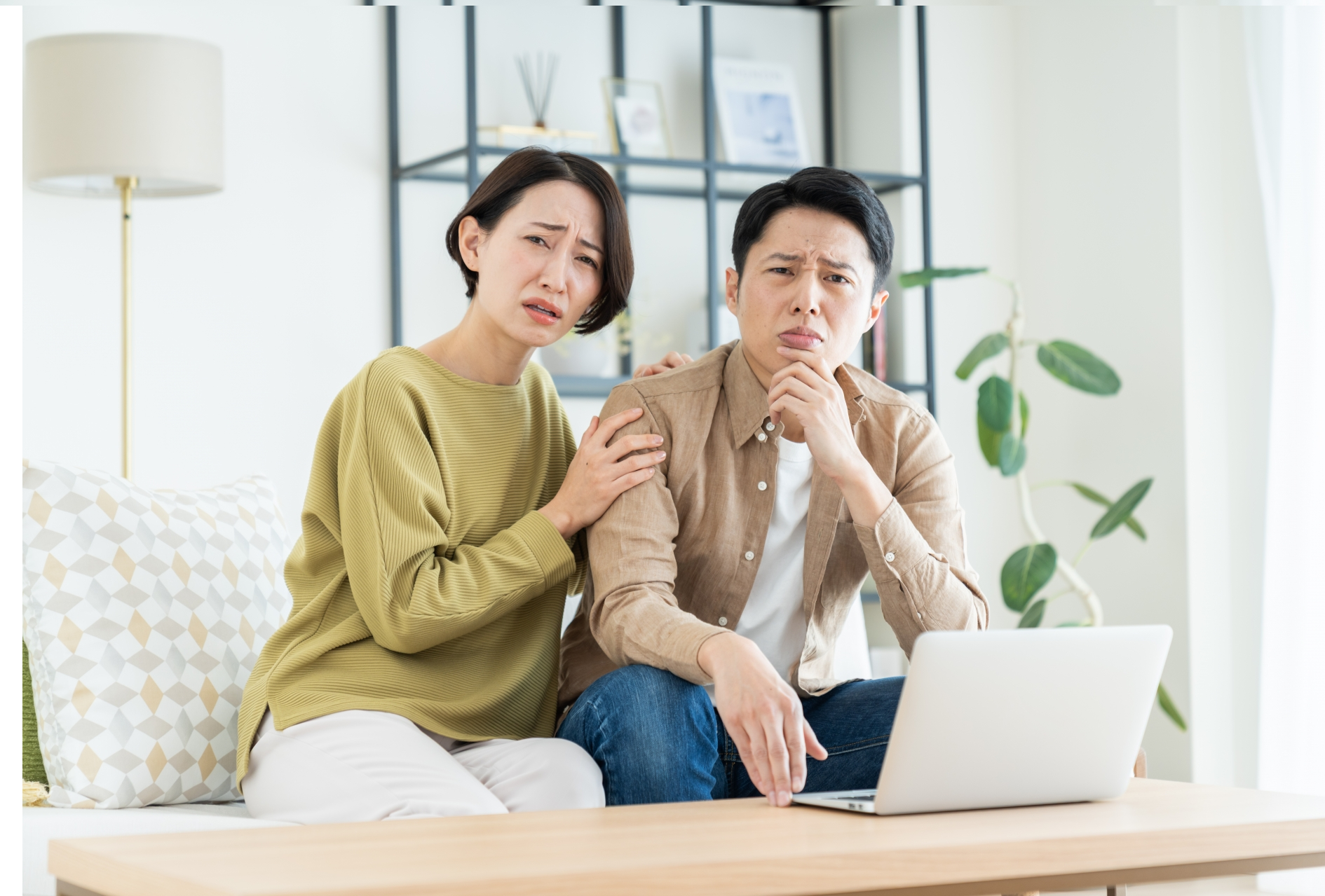 パソコンを前に眉を顰める男女