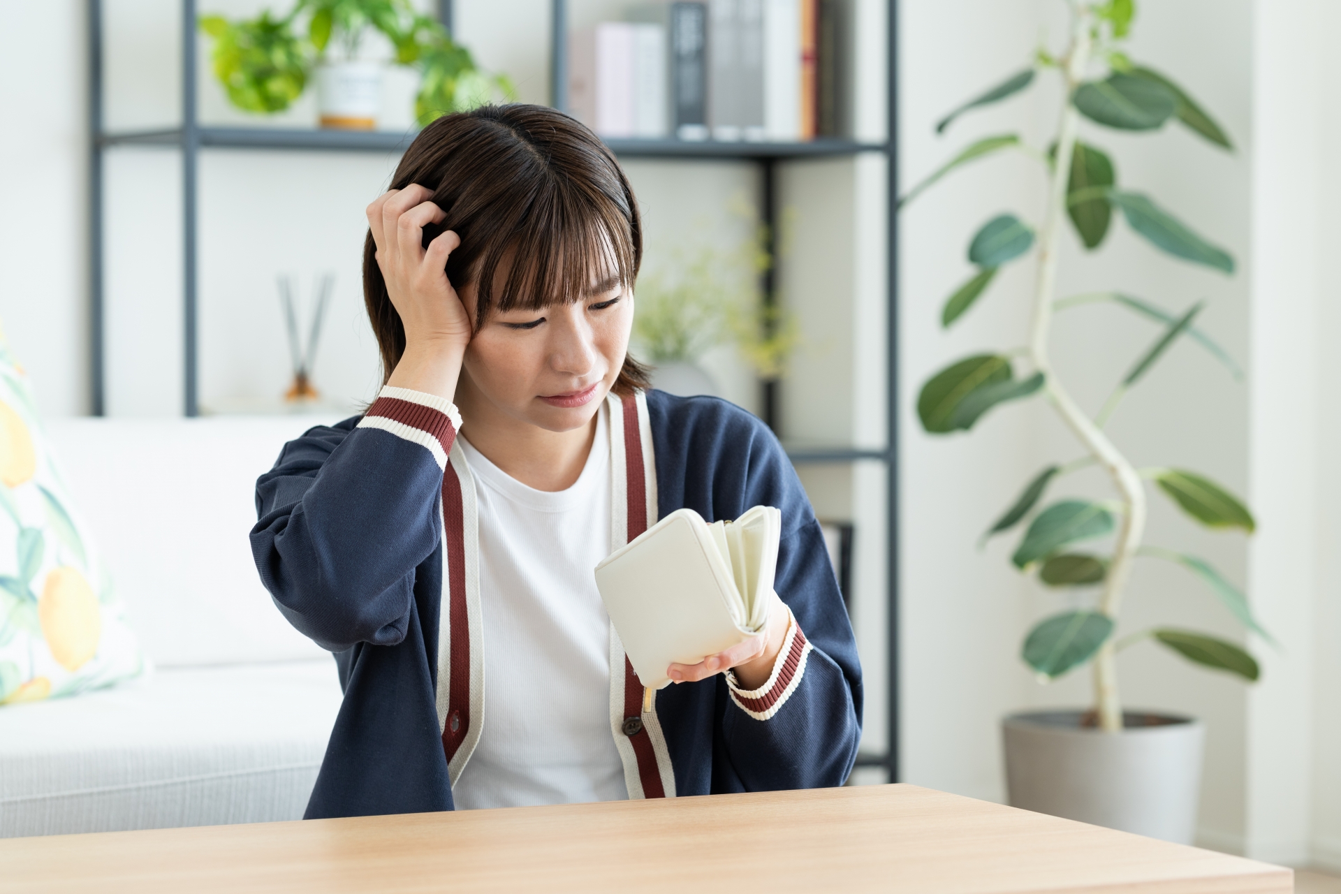 悲しそうに財布の中を見る女性