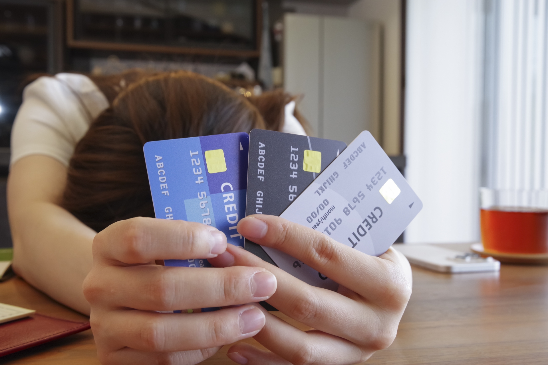 クレジットカードを持って悩む女性