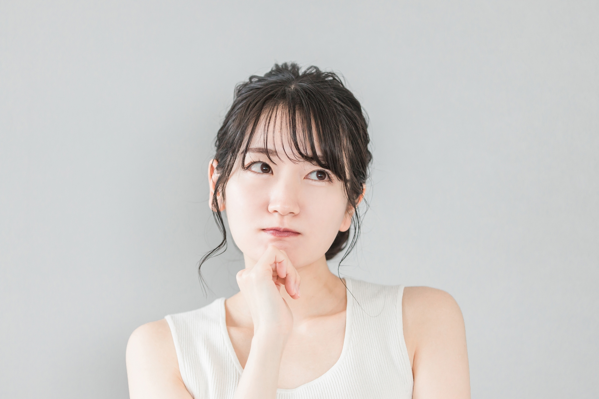 上目遣いで考える女性