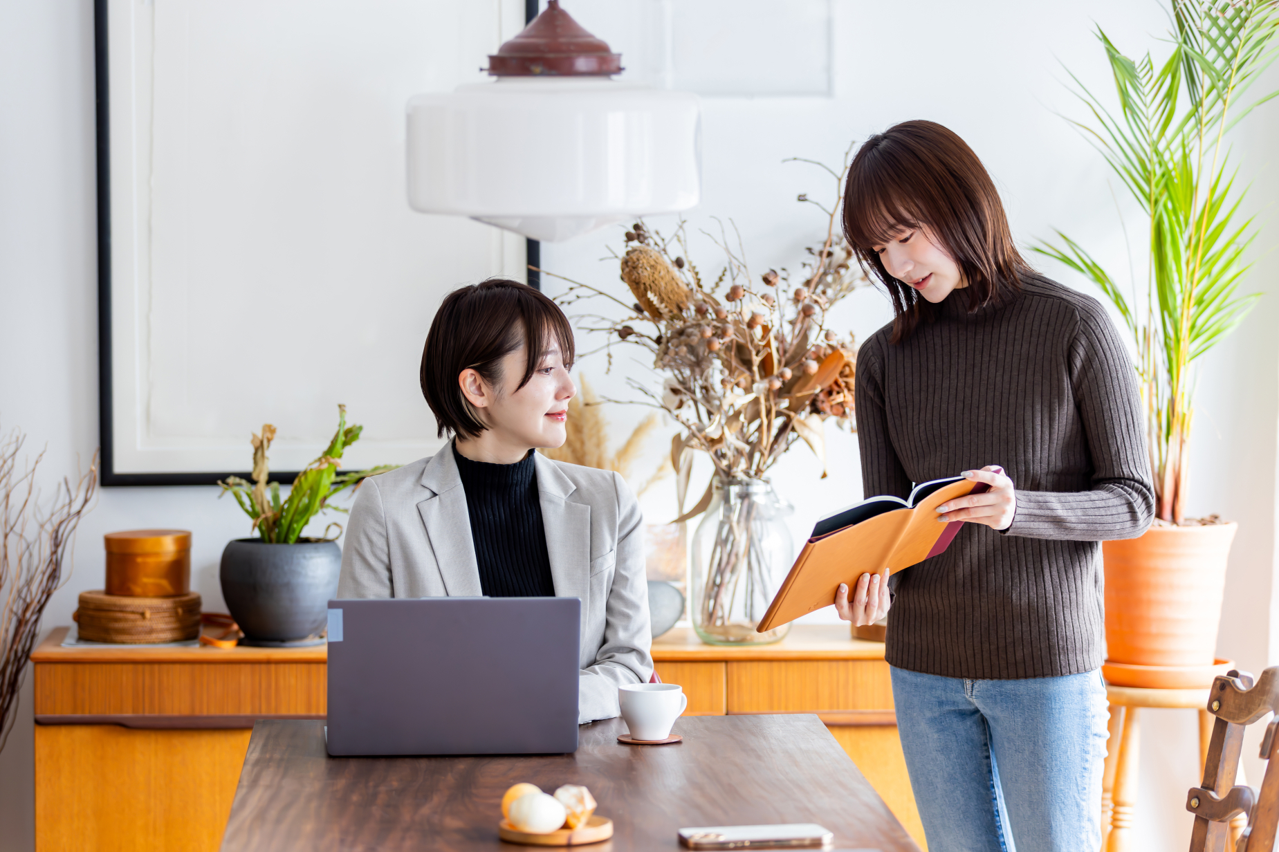 本を見て話し合う女性2人
