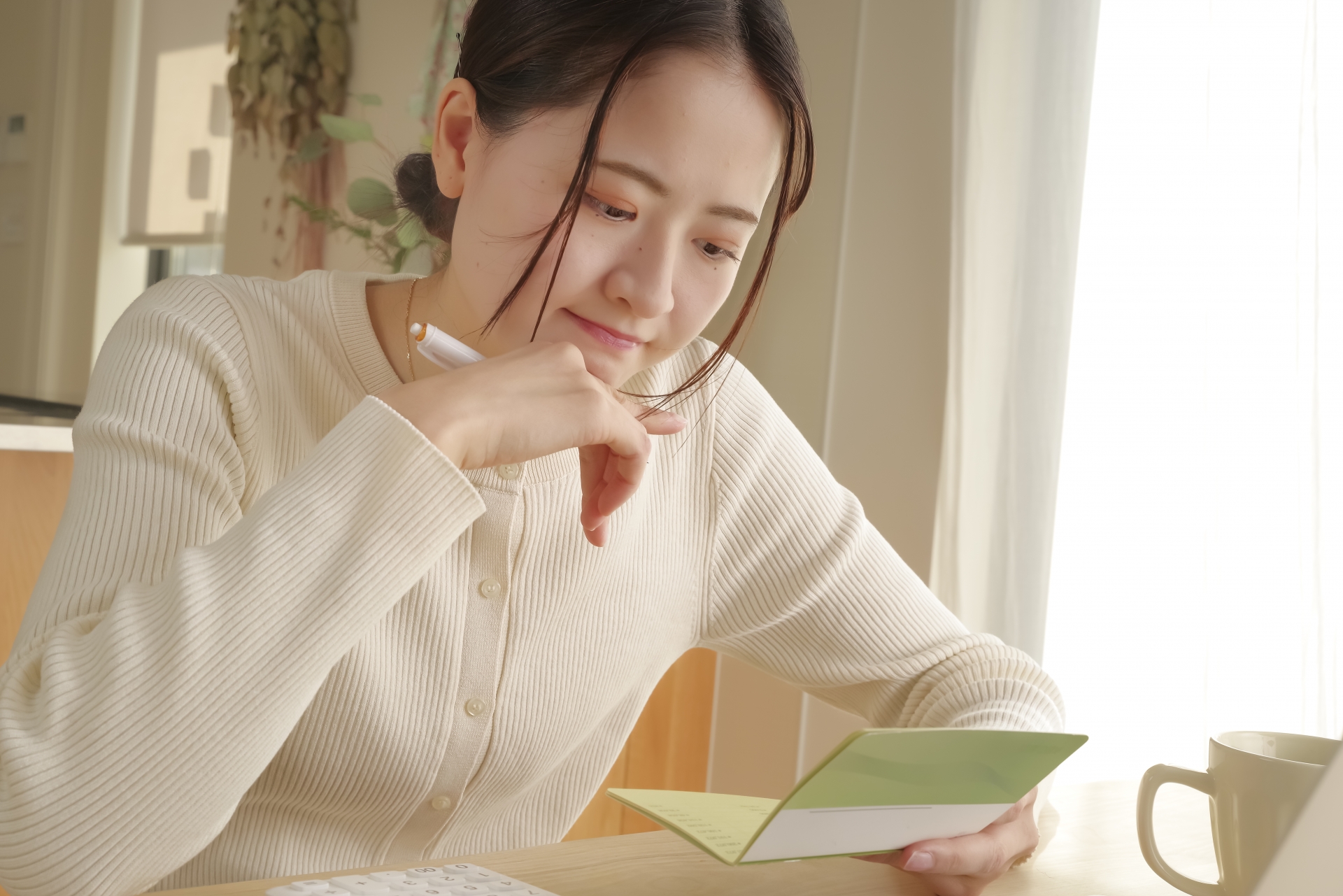 通帳を見て考える女性