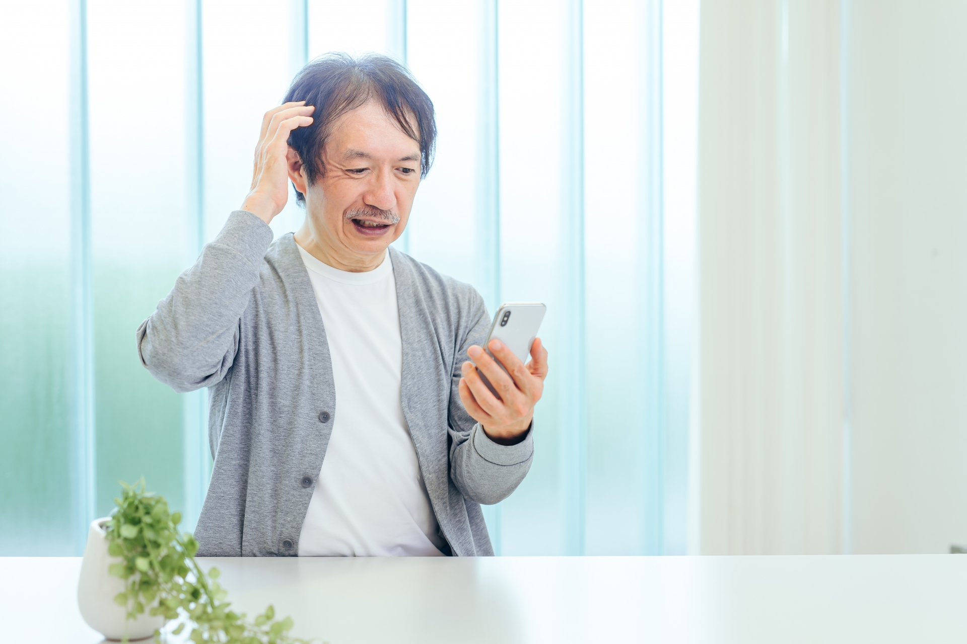スマホを見て困った男性