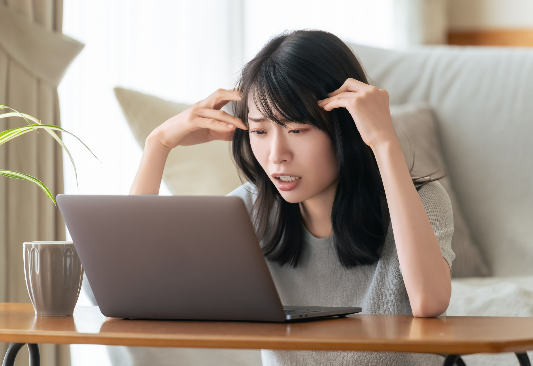 パソコン前で頭を抱える女性