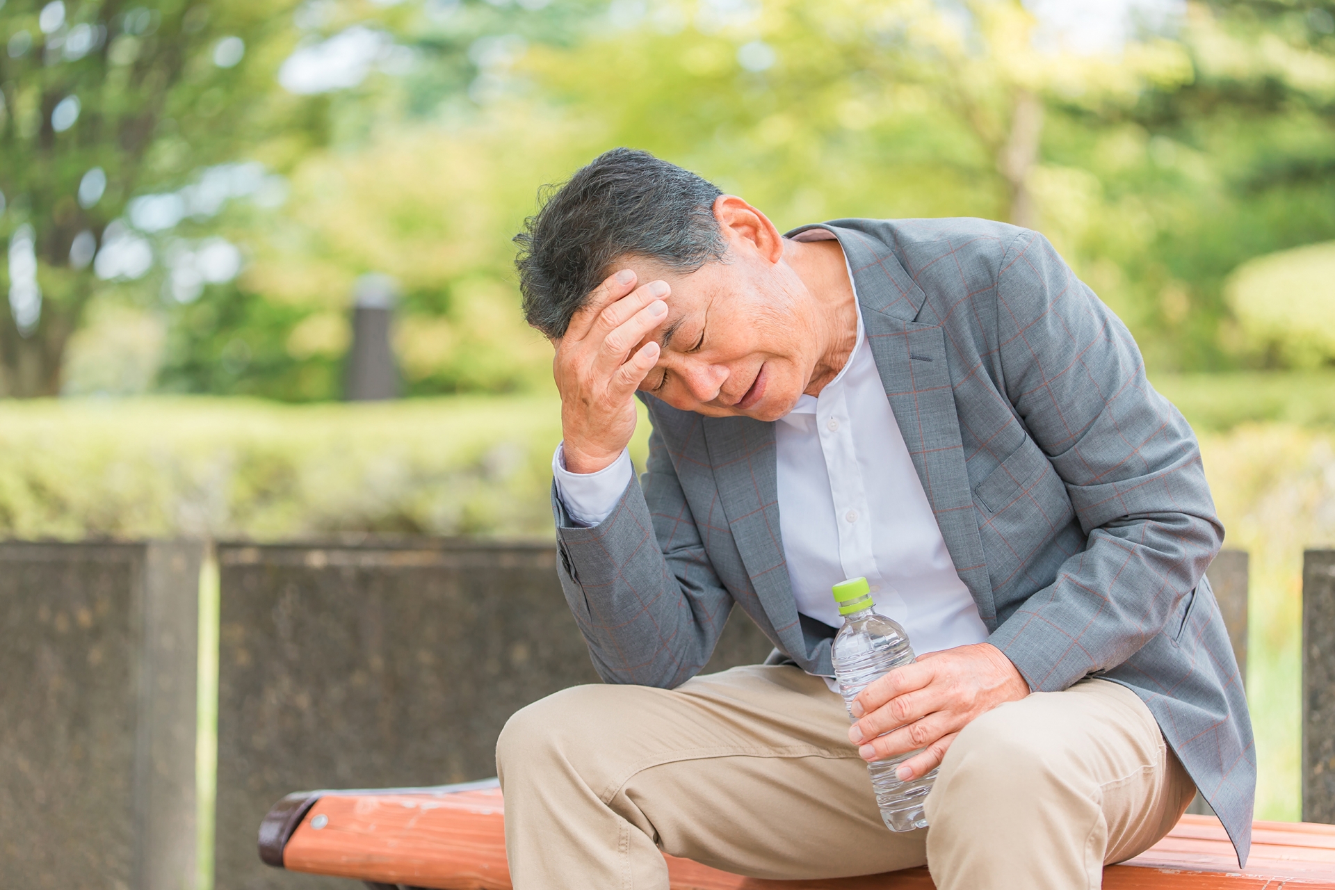 ベンチで頭を抱える男性