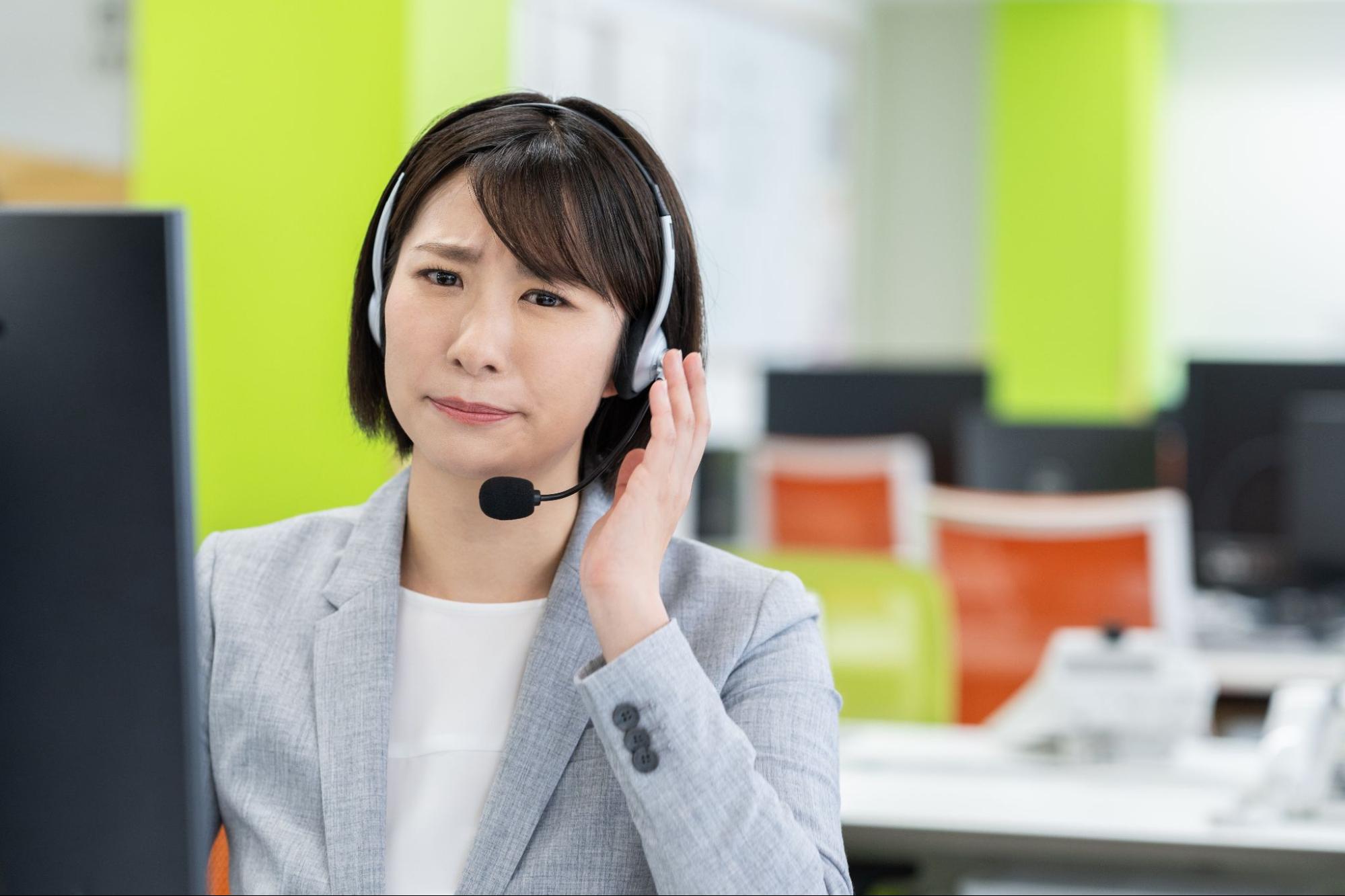 悩むコールセンターの女性