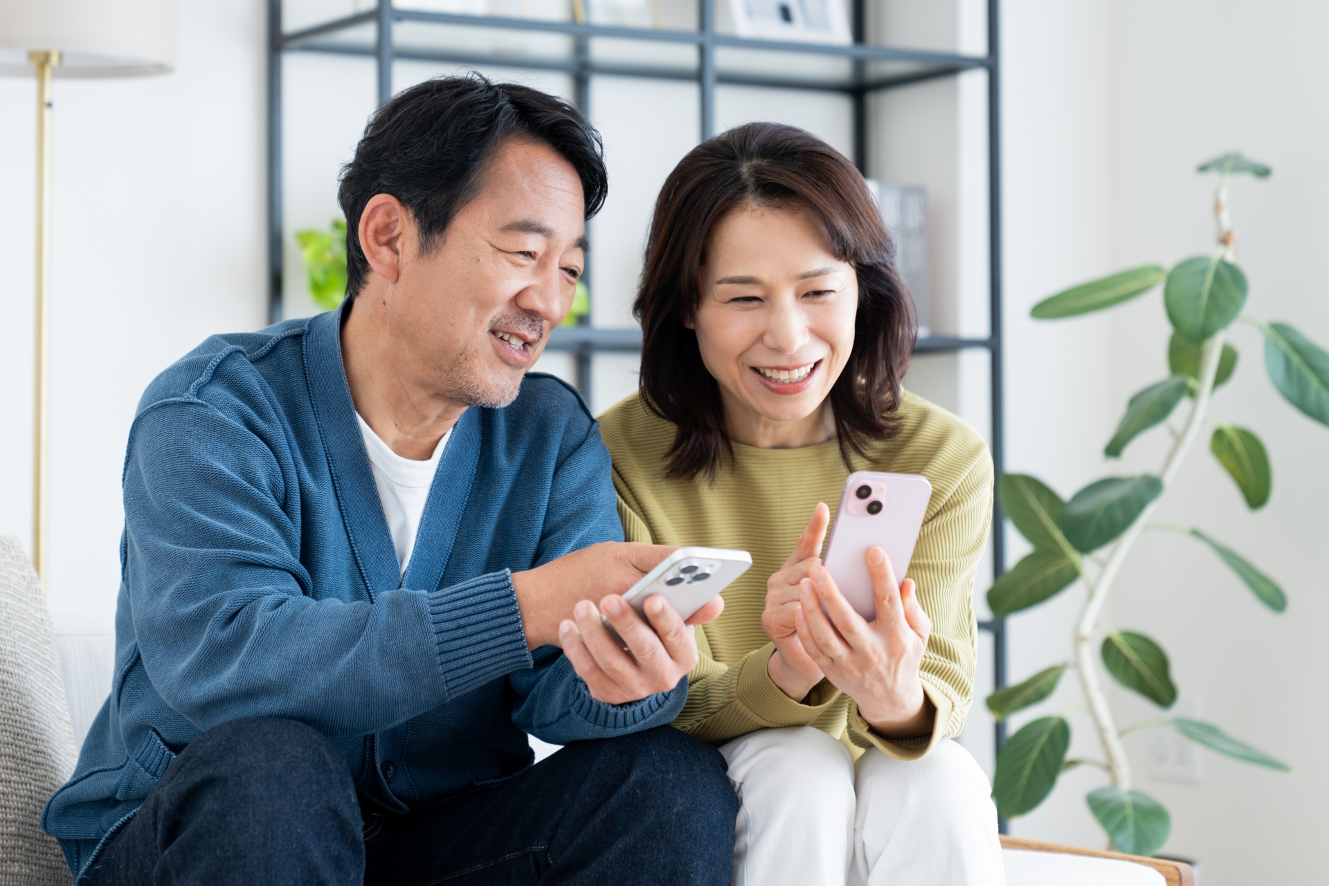 笑顔でスマホを見せ合う男女