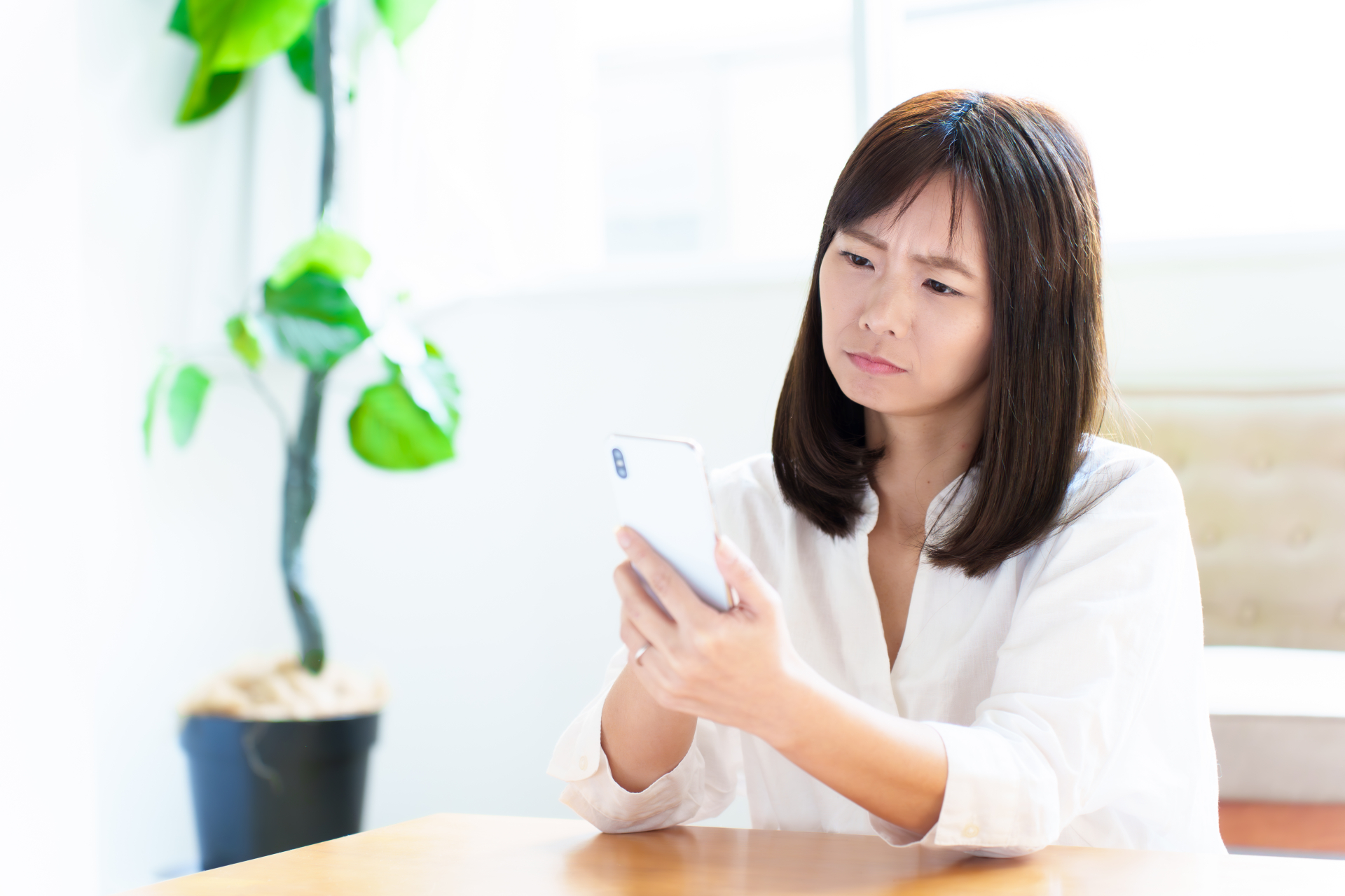 辛そうにスマホを見る女性