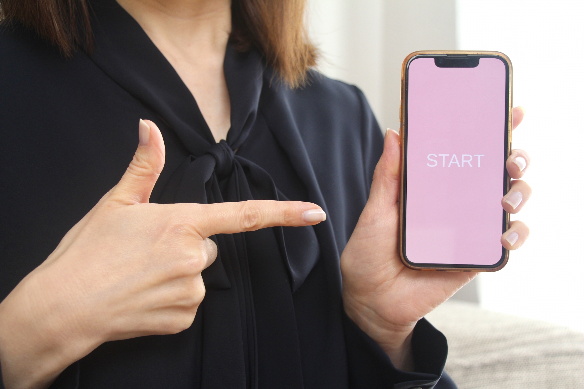 スマホを指さす女性