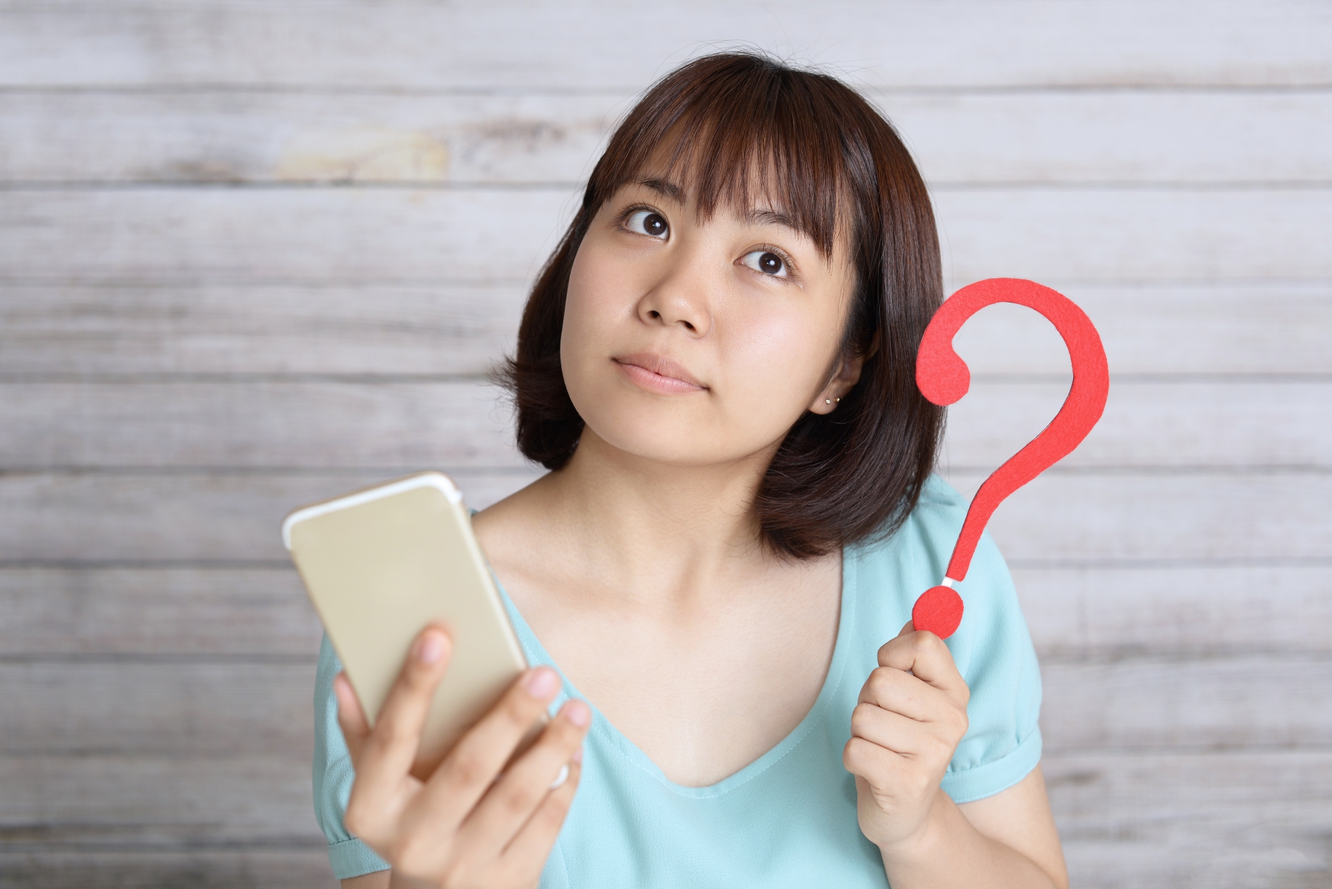 携帯を持ち悩む女性