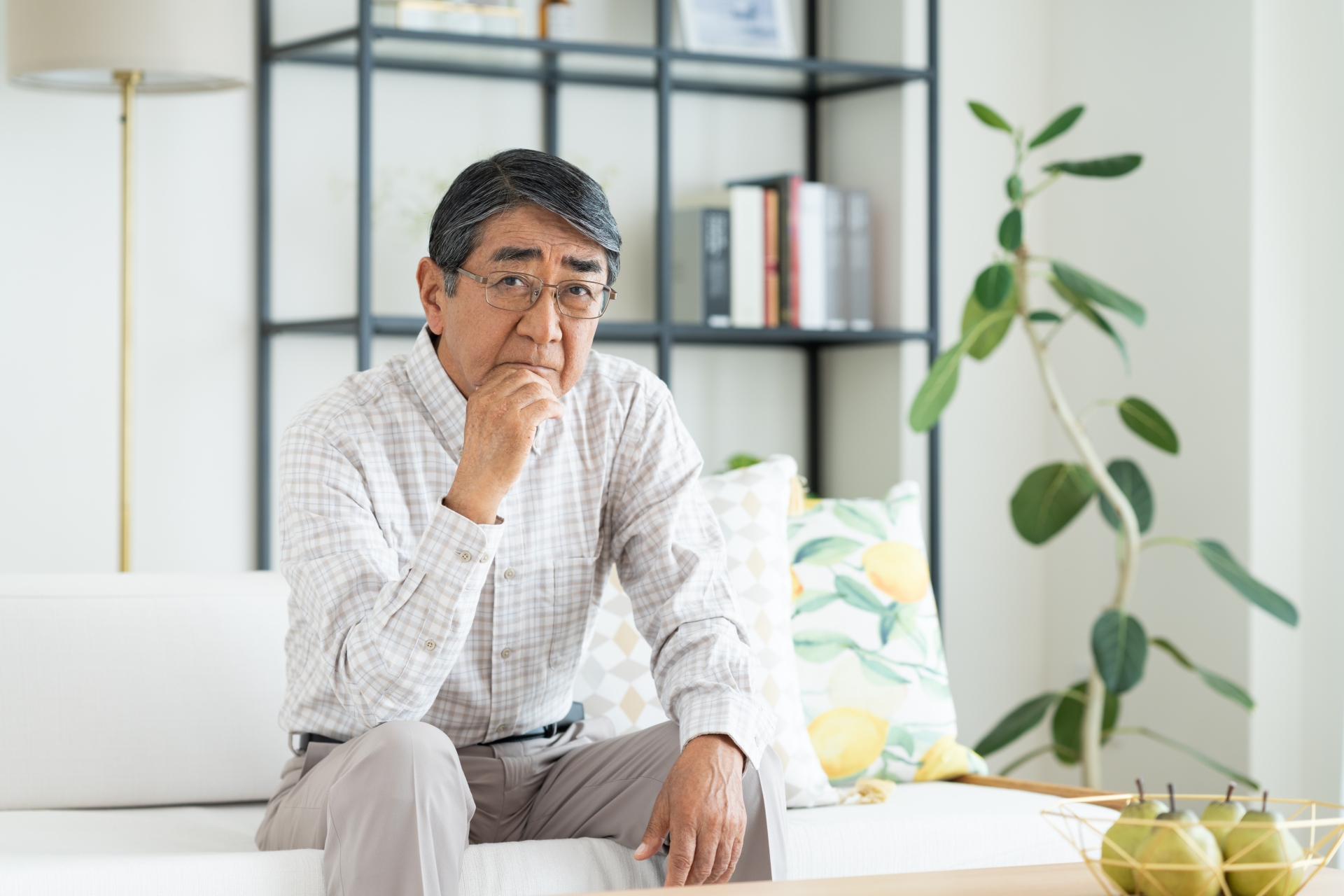 ソファに座り考える男性
