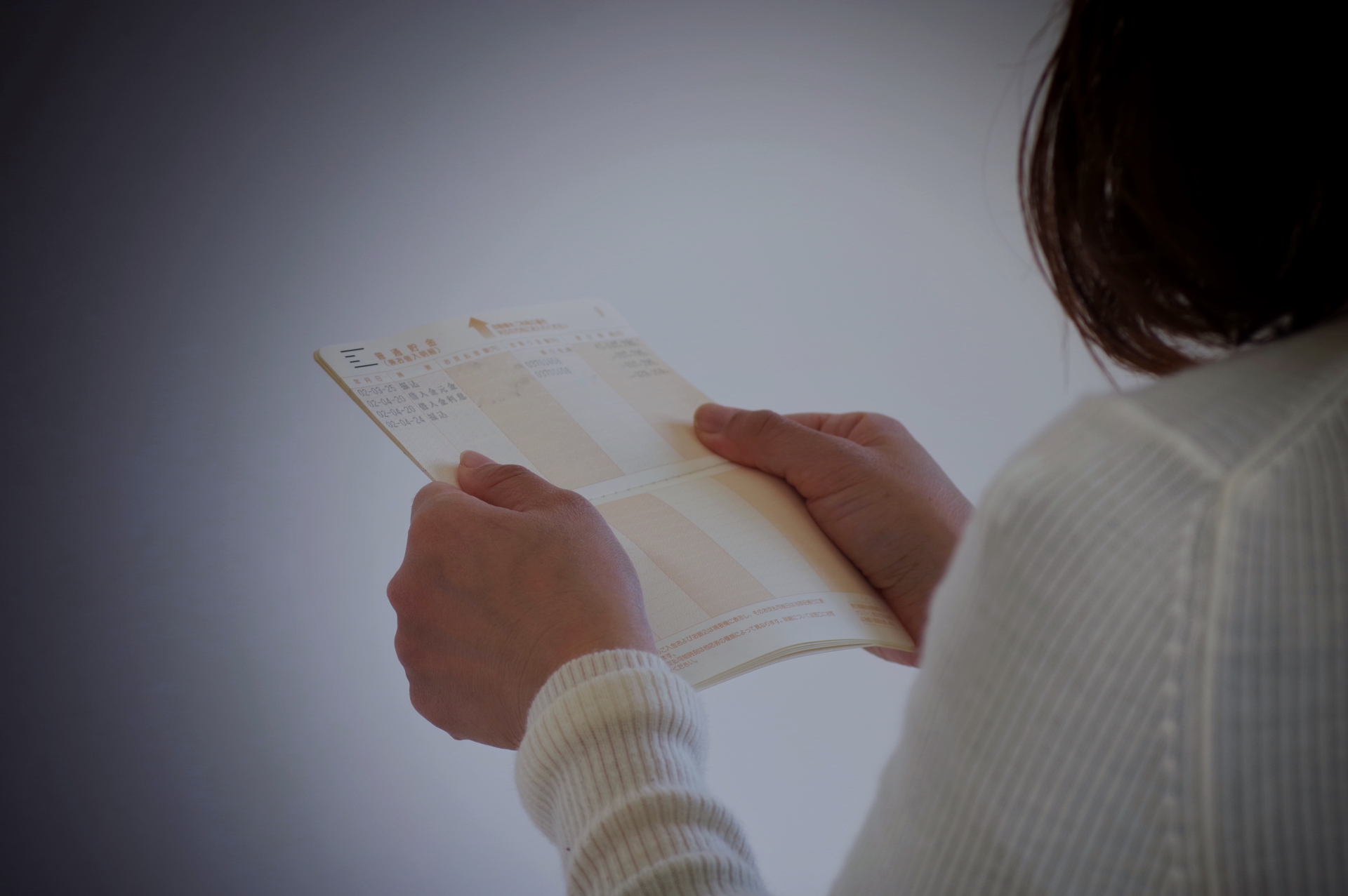 通帳を手にする女性